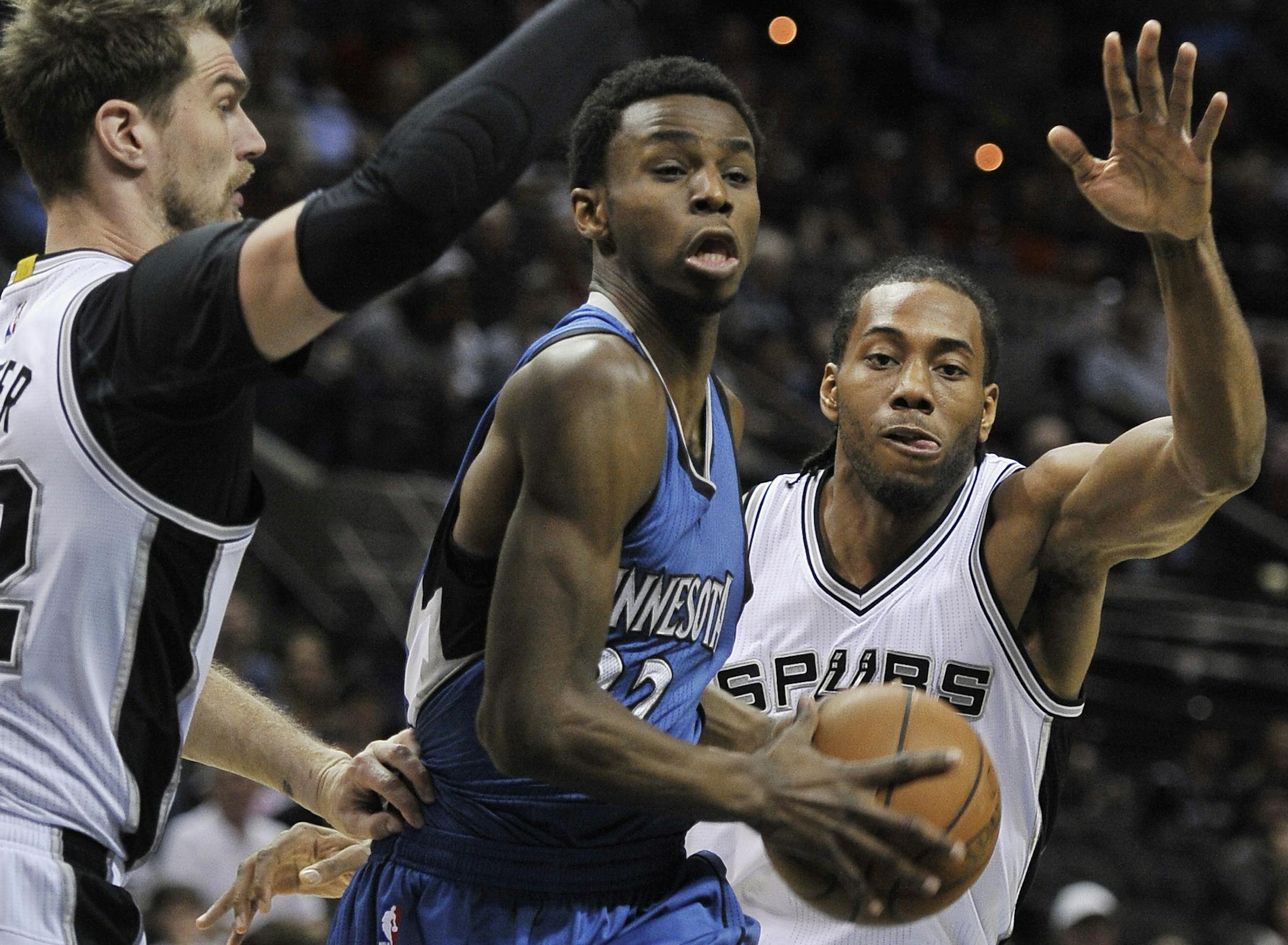 Minnesota Timberwolves guard Andrew Wiggins, center, drives between San Antonio Spurs forwards Kawhi Leonard, right, and Tiago Splitter, of Brazil, during the first half of an NBA basketball game, Sunday, March 15, 2015, in San Antonio. (AP Photo/Darren Abate) ORG XMIT: MIN2015031520355253