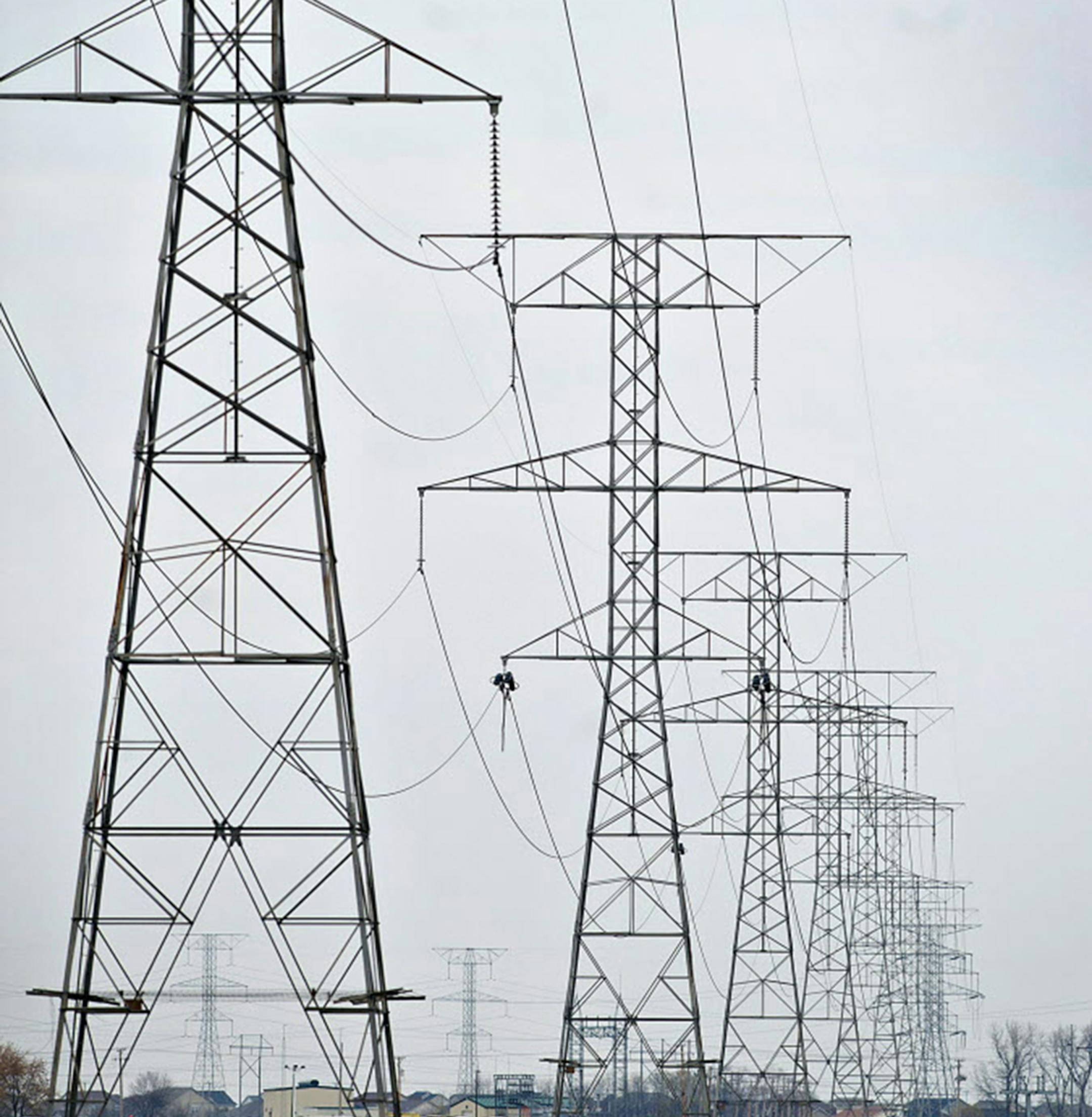 Electrical lines hang from transmission towers near the natural gas fired 1200-megawatt Kendall Energy power plant, owned by Dynegy Inc., in Minooka, Illinois, U.S., on Sunday, Nov. 6, 2011. Dynegy Inc. and its bondholders are headed to a possible showdown in bankruptcy court after the third-largest independent U.S. power producer withdrew an offer to swap as much as $1.25 billion of notes for cash and new debt valued at 28 to 60 percent of face value. Photographer: Daniel Acker/Bloomberg ORG XM