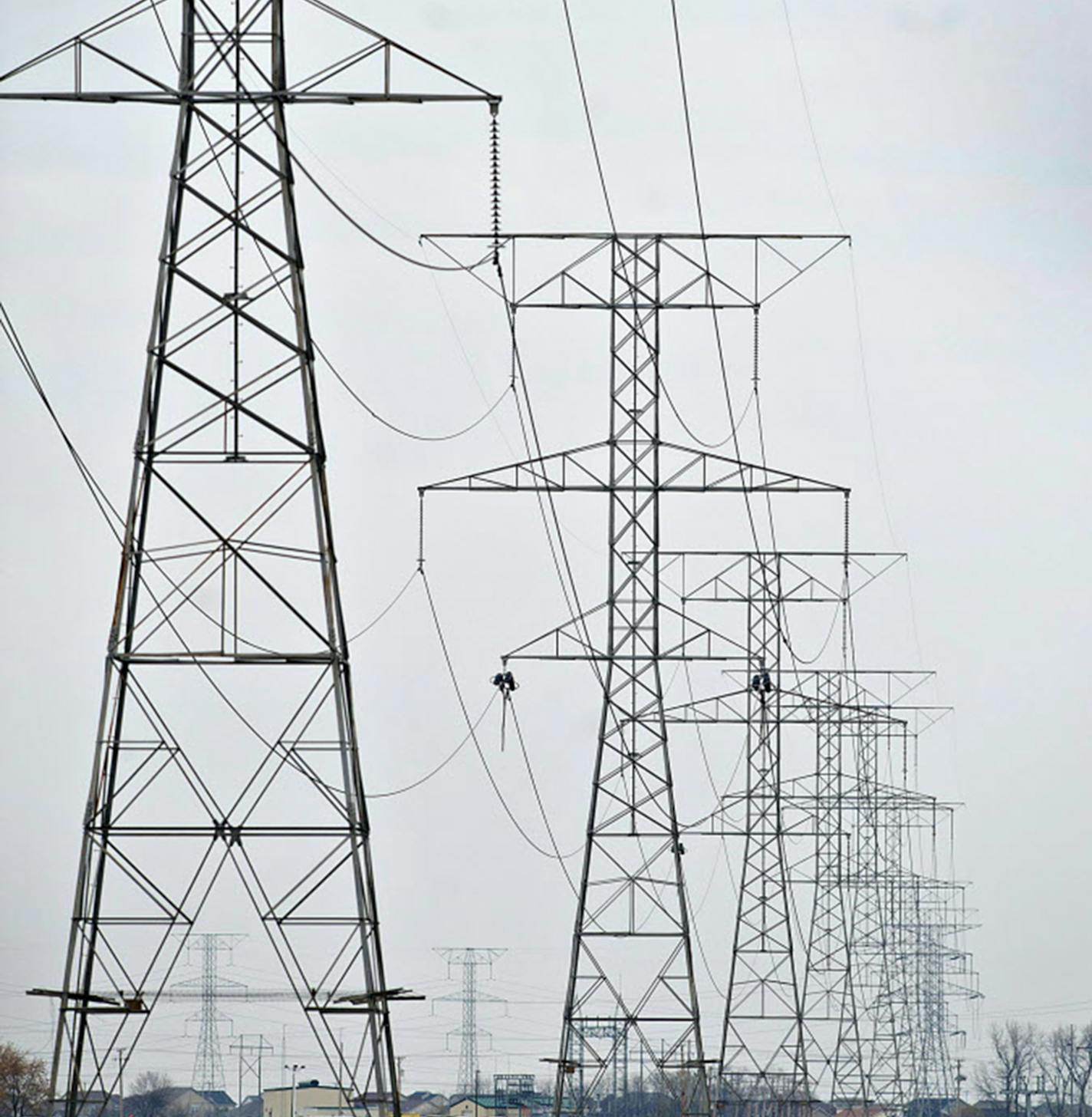 Electrical lines hang from transmission towers near the natural gas fired 1200-megawatt Kendall Energy power plant, owned by Dynegy Inc., in Minooka, Illinois, U.S., on Sunday, Nov. 6, 2011. Dynegy Inc. and its bondholders are headed to a possible showdown in bankruptcy court after the third-largest independent U.S. power producer withdrew an offer to swap as much as $1.25 billion of notes for cash and new debt valued at 28 to 60 percent of face value. Photographer: Daniel Acker/Bloomberg ORG XM