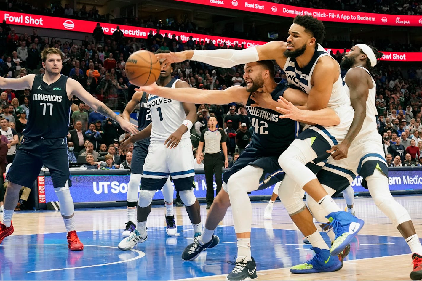 Dallas Mavericks forward Maxi Kleber (42) and Minnesota Timberwolves center Karl-Anthony Towns, second from right, reach for the ball in front of Mavericks guard Luka Doncic (77) and Timberwolves guard Patrick Beverley, right, in the final seconds of the second half of an NBA basketball game in Dallas, Monday, March 21, 2022. (AP Photo/LM Otero)