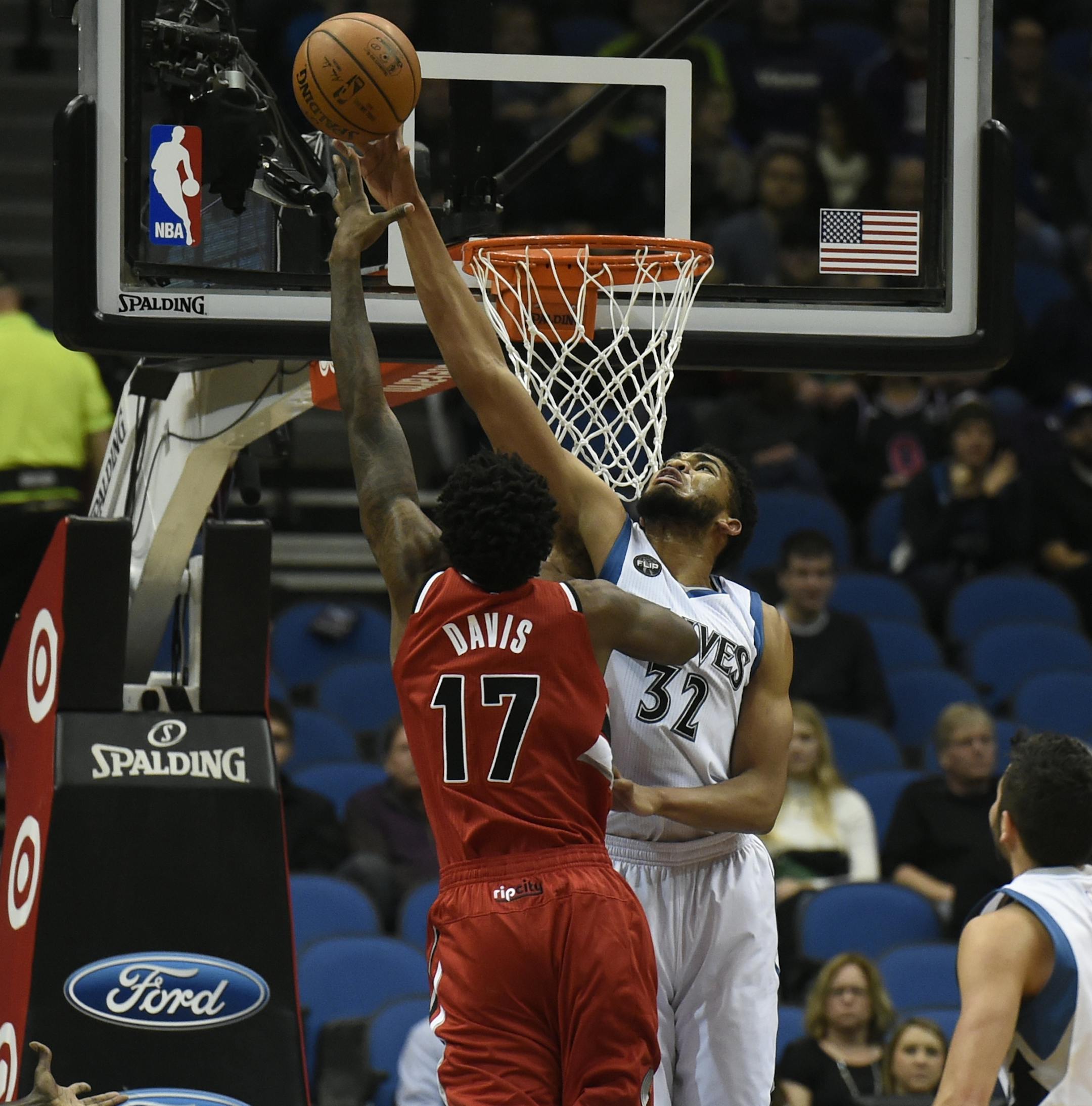 Minnesota Timberwolves center Karl-Anthony Towns (32) blocks a shot by Portland Trail Blazers center Ed Davis (17) during the first quarter of an NBA basketball game on Saturday, Dec. 5, 2015, in Minneapolis. The Trail Blazers won 109-103. (AP Photo/Hannah Foslien) ORG XMIT: OTKHF122