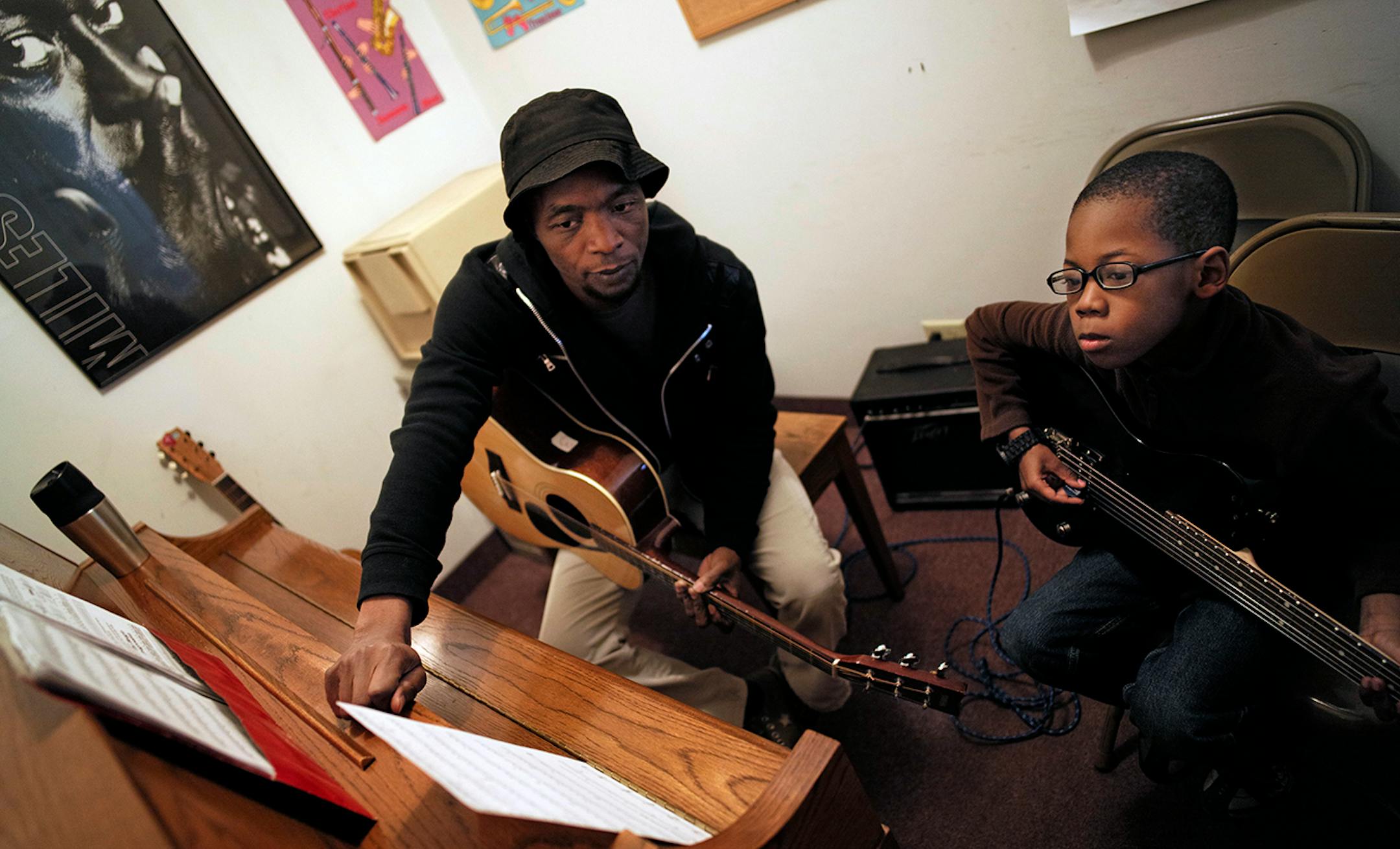 Walker West Music Academy guitar instructor gave some tips to Isaiah Bailey,8, who is learning the electric guitar. The institution in St. Paul's Summit University neighborhood that has been teaching folks how to make music for 26 years is moving to bigger and newer digs soon, just across the street.]richard.tsong-taatarii/rtsong-taatarii@startribune.com