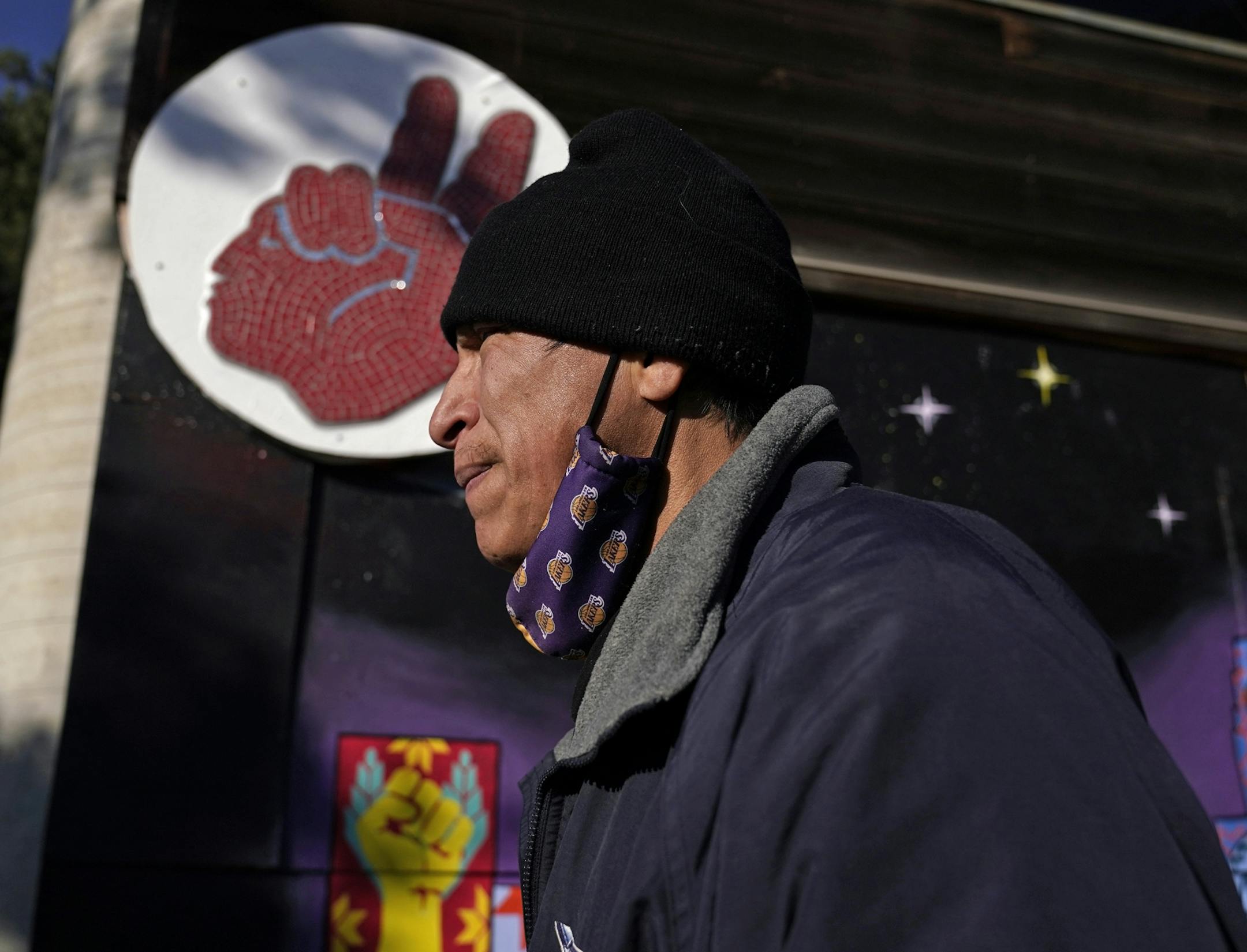 Allen Touche, 48, walked along Franklin Ave., past the Minneapolis American Indian Center and an American Indian Movement symbol recently during his weekly Saturday journey to help feed homeless Natives and others in Minneapolis.