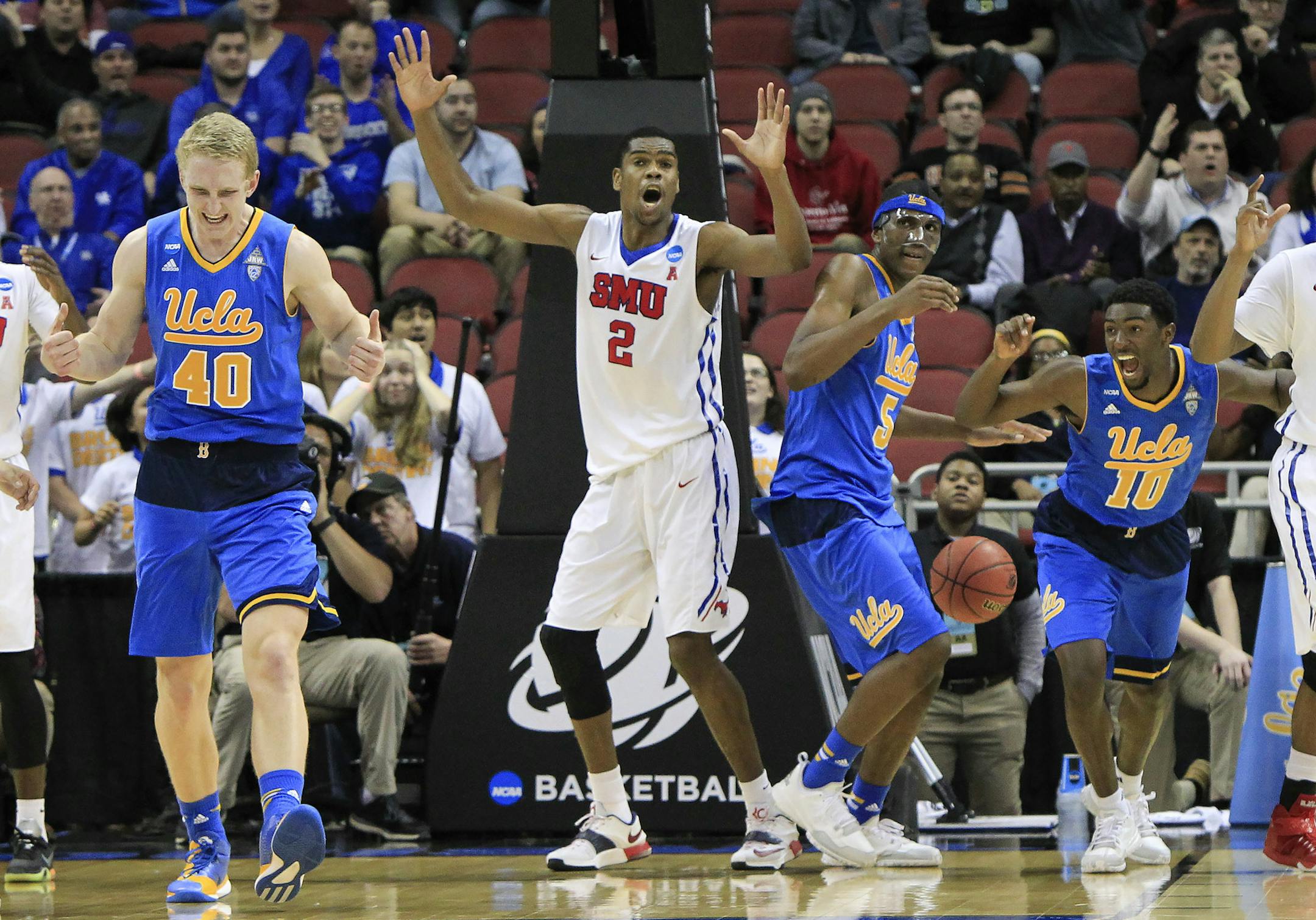 UCLA and SMU players react to a goaltending call on SMU center Yanick Moreira (2) during the second half in the second round of the NCAA college basketball tournament in Louisville, Ky., Thursday, March 19, 2015. UCLA won 60-59. (AP Photo/David Stephenson)
