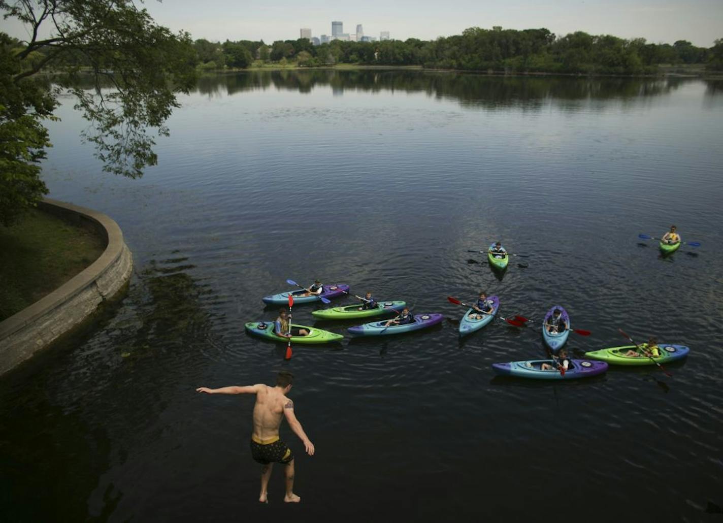 A group of kayakers watched as Matt Kreye jumped in to Lake of the Isles, Tuesday, June 9, 2015, in Minneapolis.