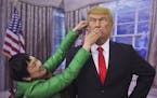 In this Wednesday, March 8, 2017 photo, a Chinese woman makes fun with a wax figure of U.S. President Donald Trump as she poses for a photograph at a 