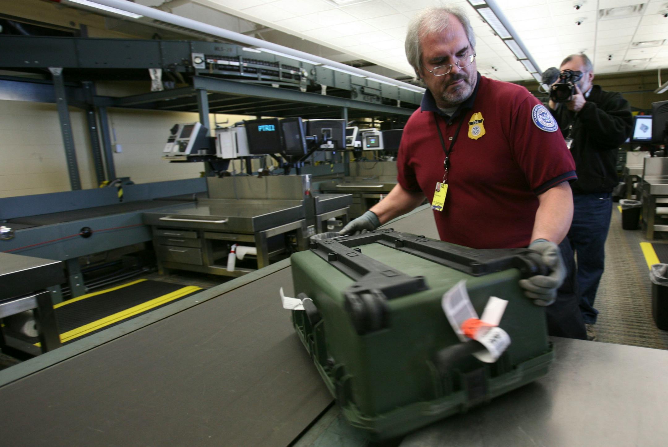 TSA employee Scott Hartfield put a bag back into the system after hand checking it as a part of the new in-line baggage screening system at the Minneapolis St. Paul International Airport.