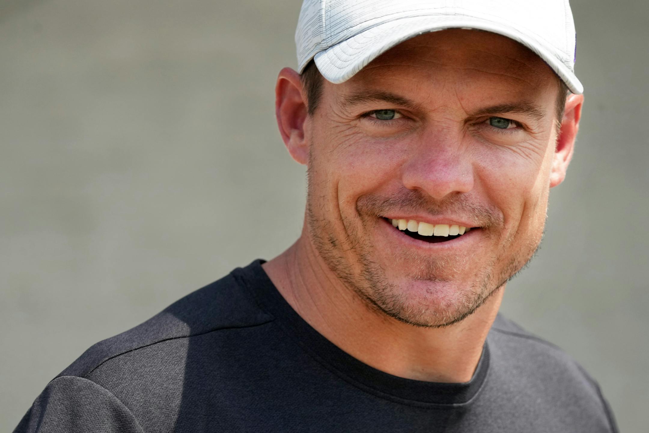 Minnesota Vikings head coach Kevin O'Connell smiles as he takes the field for training camp.