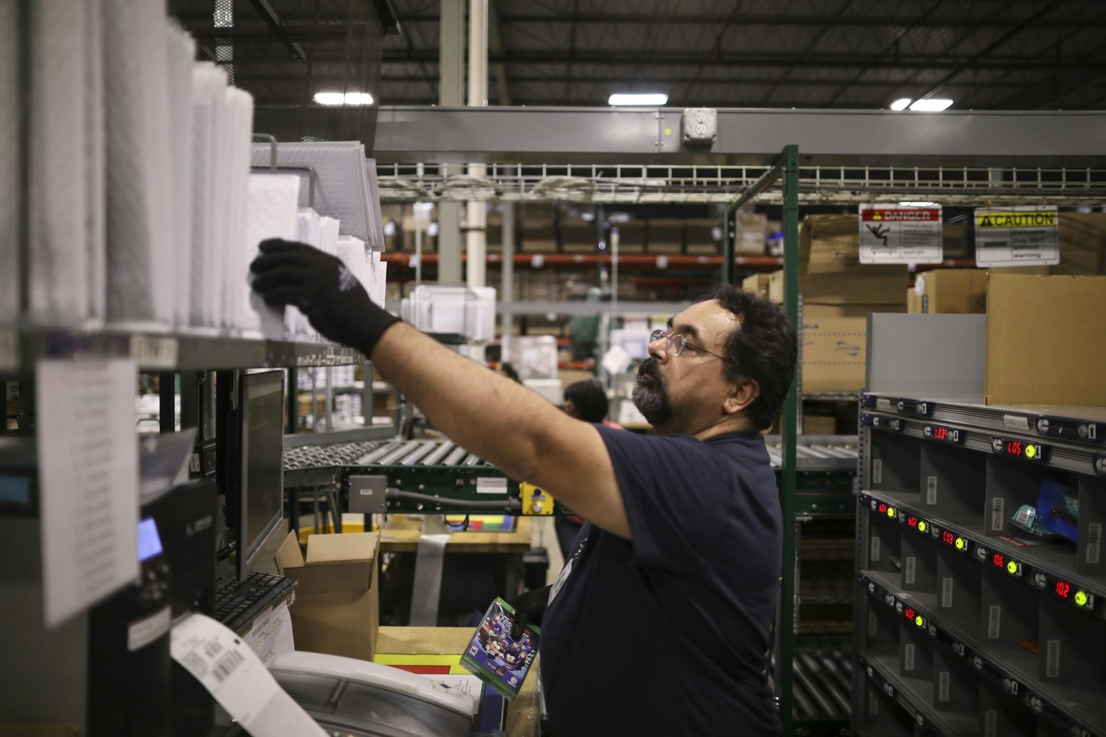 Francisco Trejo reached for a padded envelope while shipping web orders of small items to customers in the Best Buy distribution center Monday afternoon.