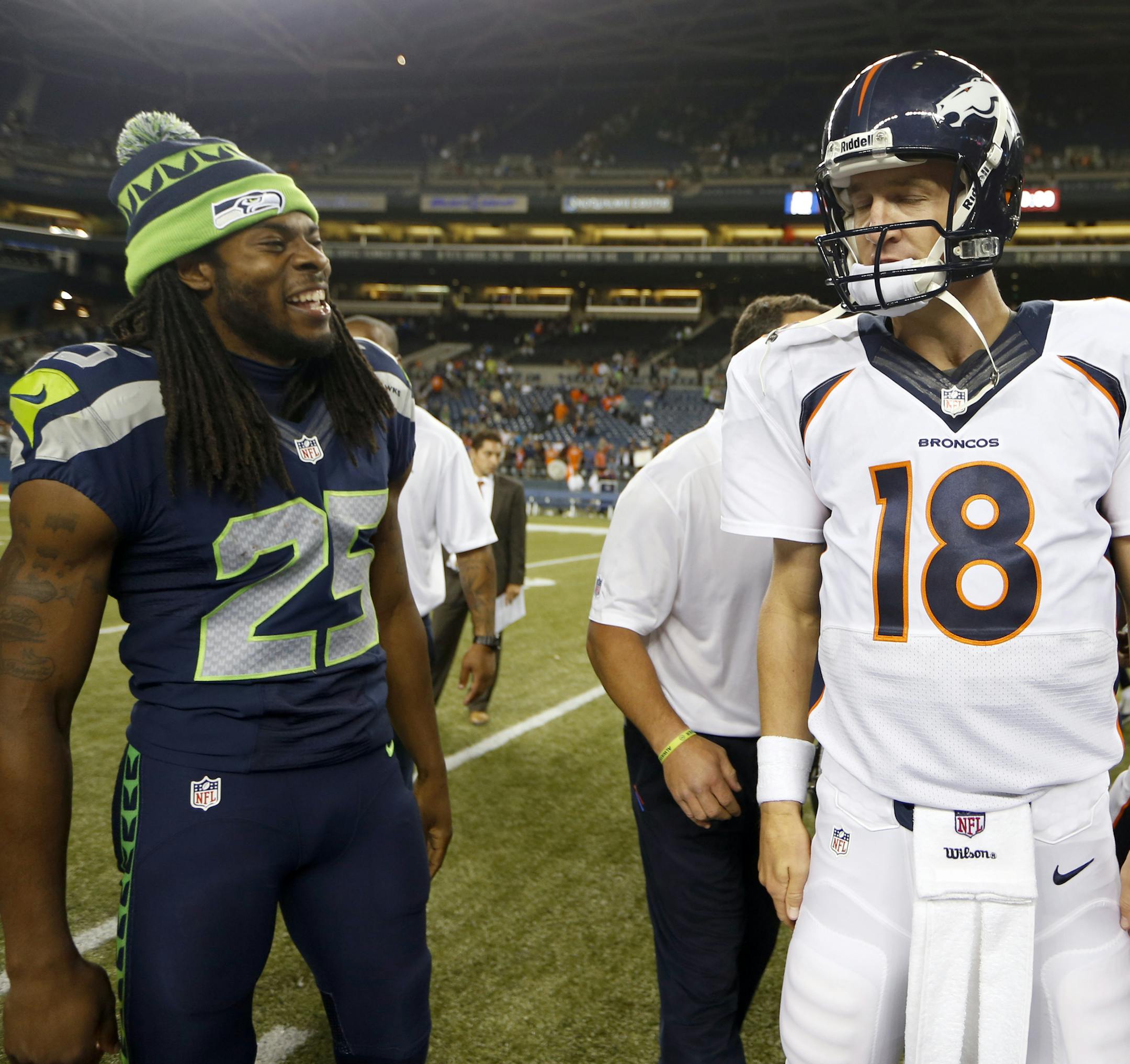 In this photo taken Aug. 17, 2013, Denver Broncos quarterback Peyton Manning (18) walks away after shaking hands with Seattle Seahawks cornerback Richard Sherman, left, after the Seahawks beat the Broncos 40-10, in a preseason NFL football game in Seattle. The two teams square off in Super Bowl XLVIII on Sunday, Feb. 2, 2014, in East Rutherford, N.J. (AP Photo/John Froschauer)