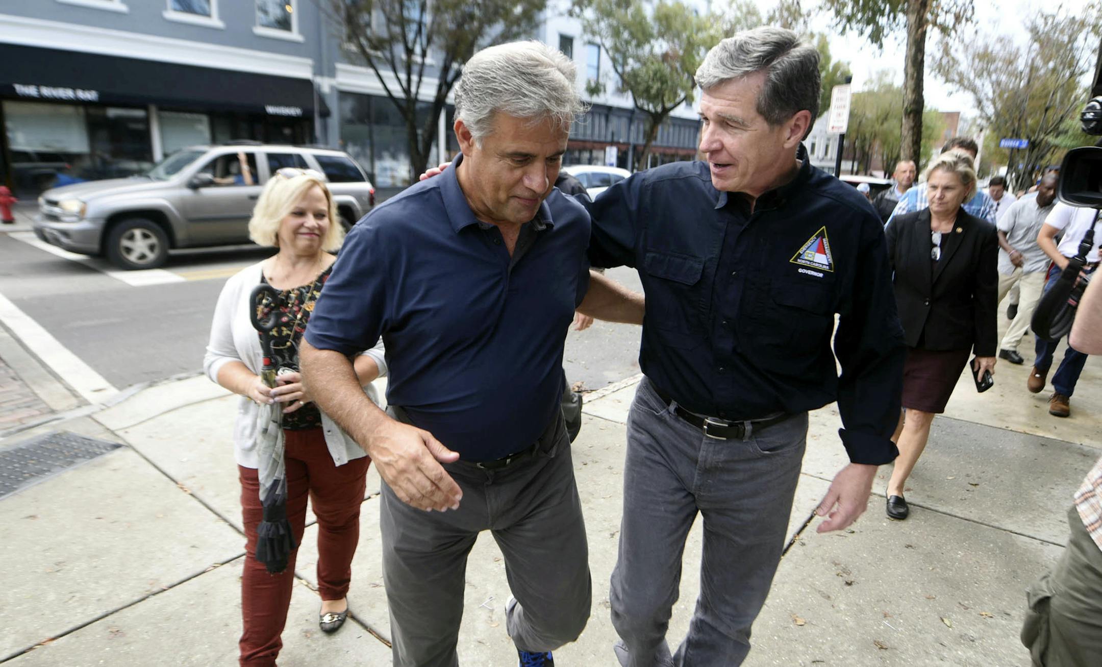 Wilmington Mayor Bill Saffo, left, and North Carolina Gov. Roy Cooper walk down Market St. during a tour of downtown Wilmington, N.C., Friday, Sept. 28, 2018. Cooper was asking business owners how Hurricane Florence impacted them both personally and professionally. (Matt Born/The Star-News via AP)