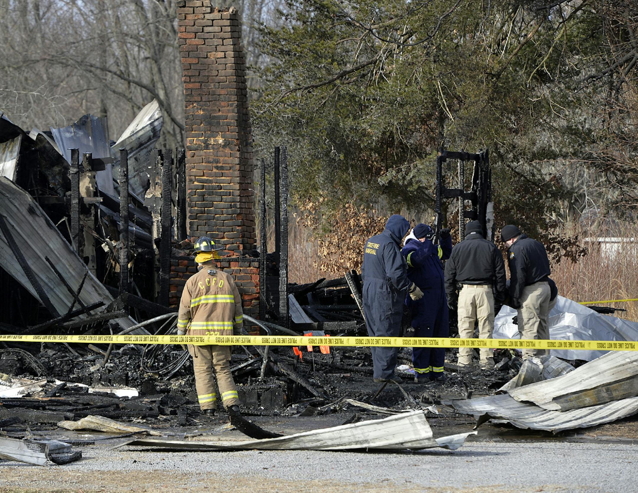 Kentucky State Fire investigators work at the scene of early morning house fire in Depoy, Ky. Thursday Jan. 30, 2014.