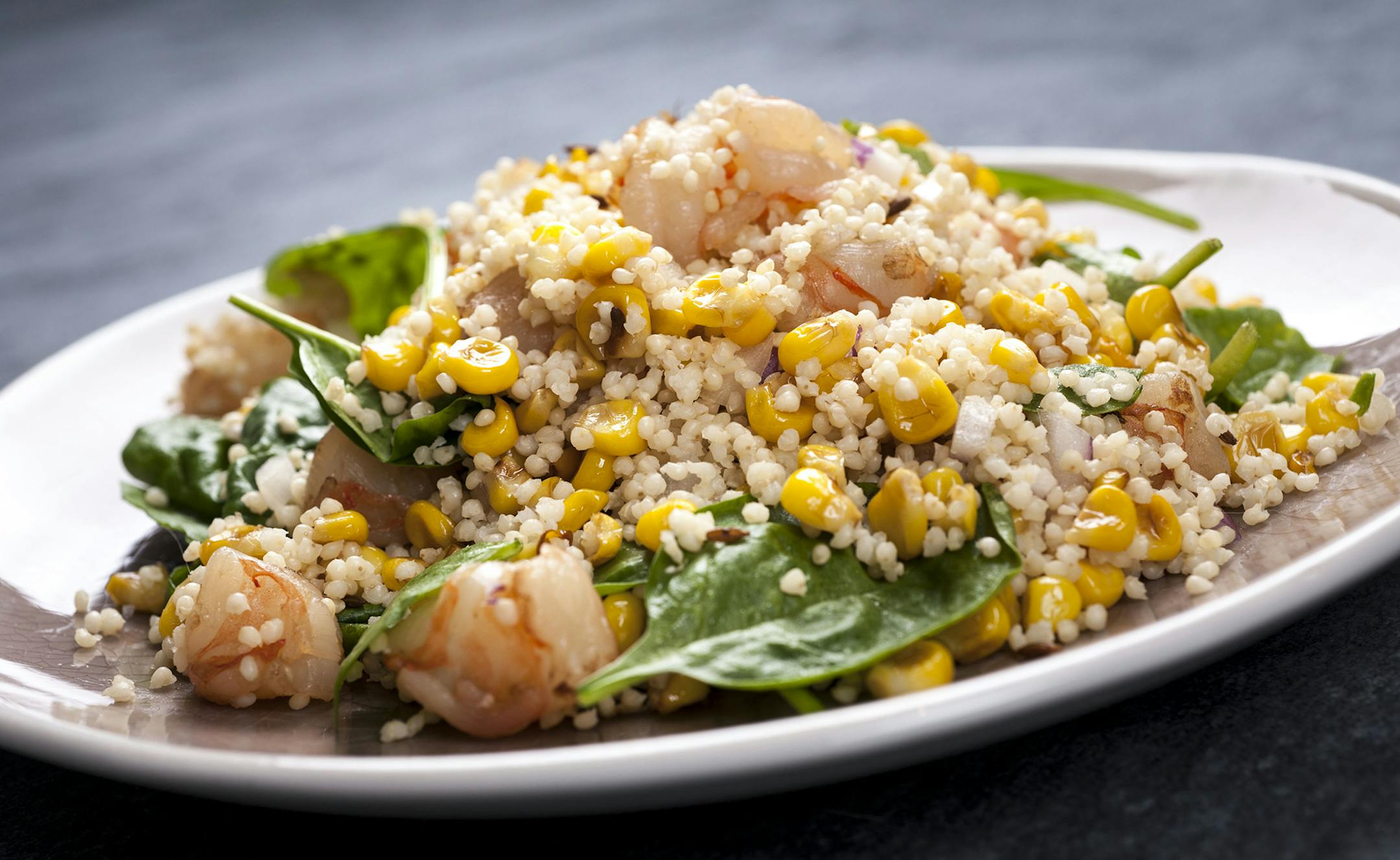 A dish of cooked millet with corn, mango and shrimp, in New York, July 16, 2013. The trick to making a good whole-grain dish is not letting the grain stand alone. (Karsten Moran/The New York Times) ORG XMIT: XNYT24