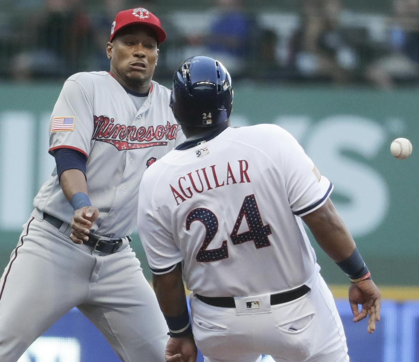 Minnesota Twins' Jorge Polanco can't handle a throw as Milwaukee Brewers' Jesus Aguilar runs to second during the first inning of a baseball game Monday, July 2, 2018, in Milwaukee. (AP Photo/Morry Gash)