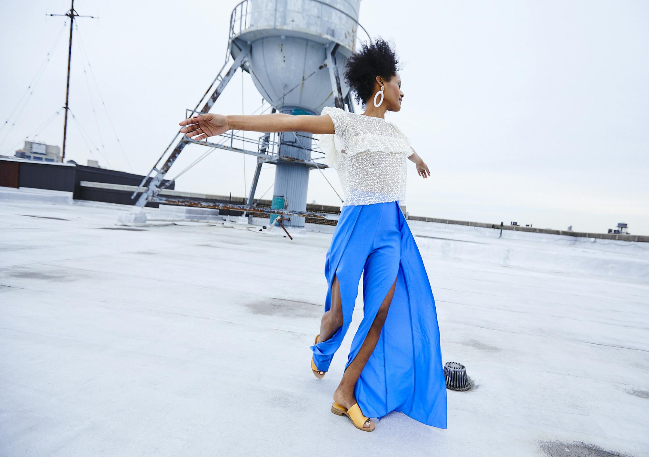 Rooftop Running
Sparkle ruffle top $40 zara.com
Blue split leg pant $169 patriziapepe.com
Baublebar Earring $17 nordstromrack.com Styling by Barbara Schmidt // Photos by Shannon Greer Hair and Make-up Artist: Morgan Blaul, morganblaul.com; Model: Meron, Wilhelmina.com