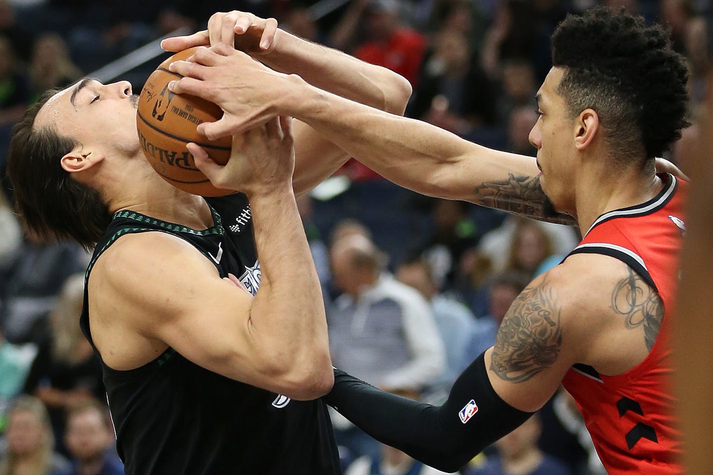 Wolves forward Dario Saric fought for possession of the ball against the Raptors' Danny Green in the first half Tuesday.