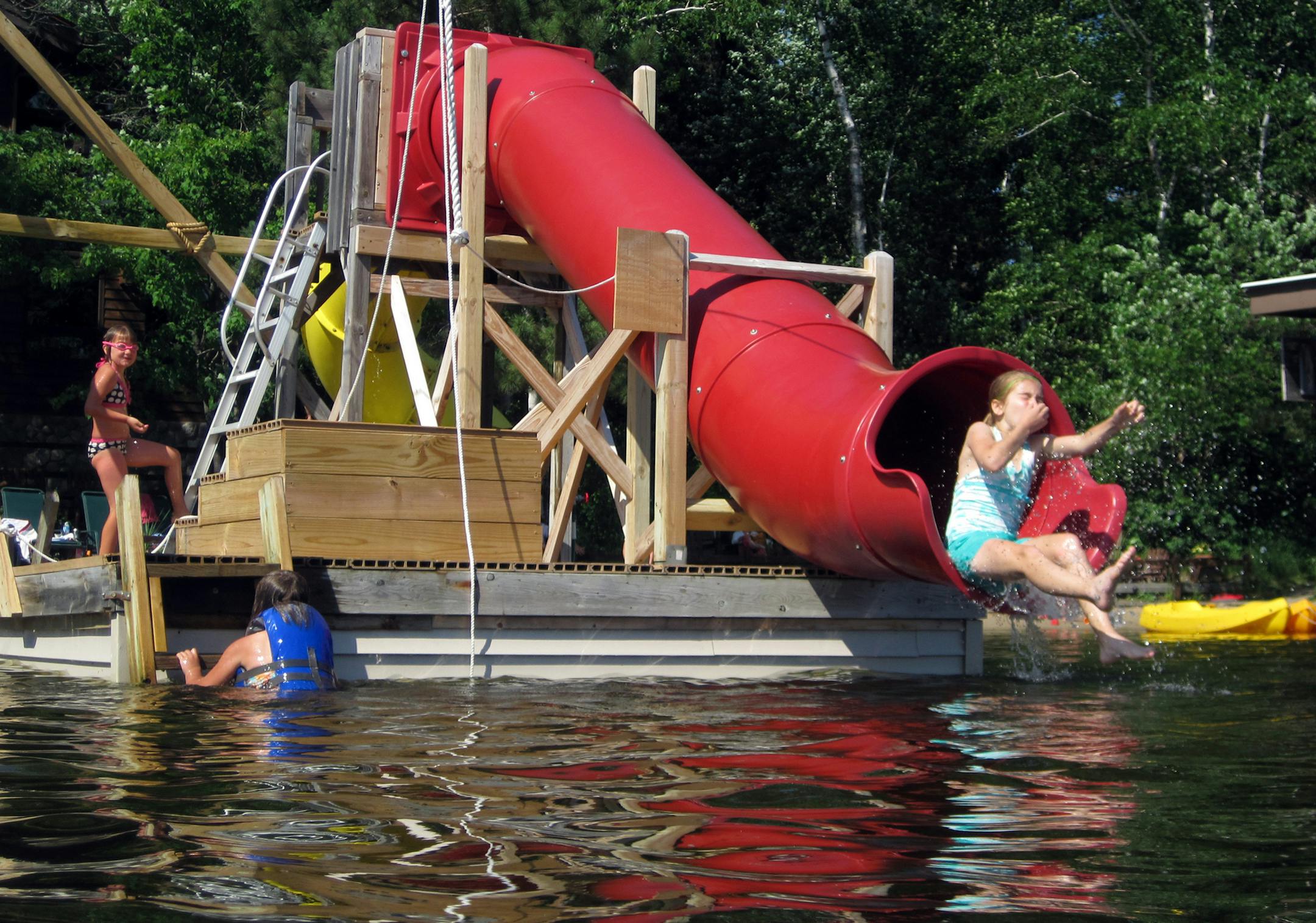 A floating dock not far from shore entices young swimmers with two slides and a wooden diving platform at Ludlow's Island Resort in Cook, Minn. ] Photo by KERRI WESTENBERG
