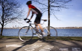 A bicyclist rides along the bike path around Lake Calhoun in Minneapolis on Wednesday, April 15, 2015. ] LEILA NAVIDI leila.navidi@startribune.com / B
