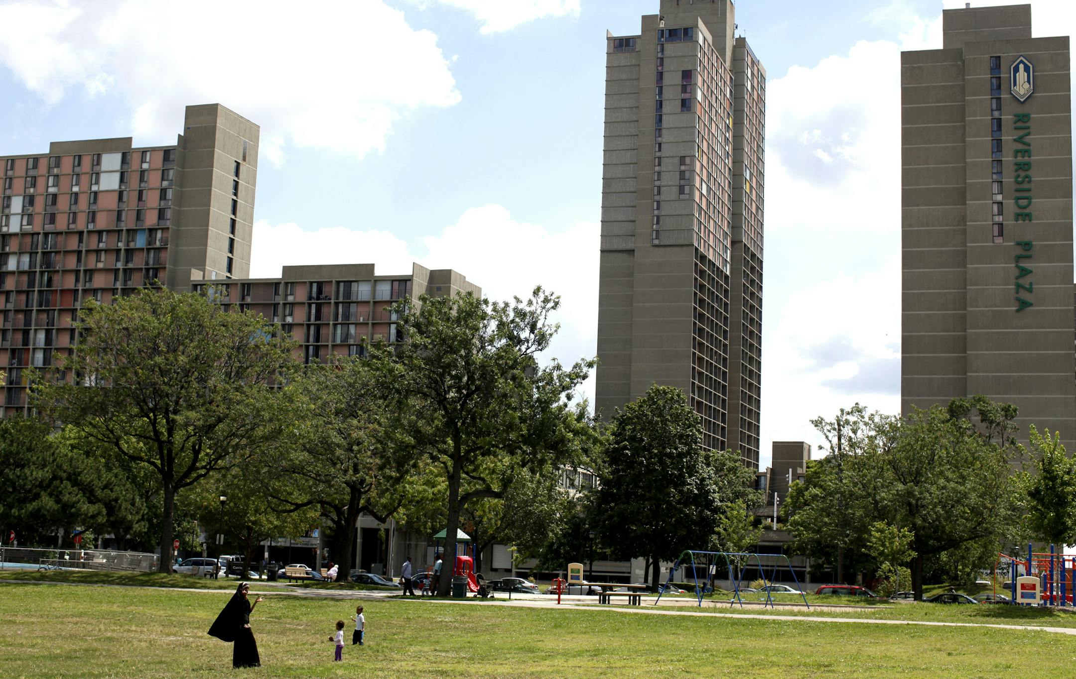 Jerry Holt • Jgholt@startribune.com Minneapolis 07/26/10:Planning to spend a large part of the day trying to meet residents and gain access to the cedar riverside towers. ..... IN THIS PHOTO: ] Families gathered Monday at Currie Park near Riverside Plaza.