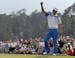 Amateur Guan Tianlang celebrates after a birdie putt on the 18th green during the first round of the Masters