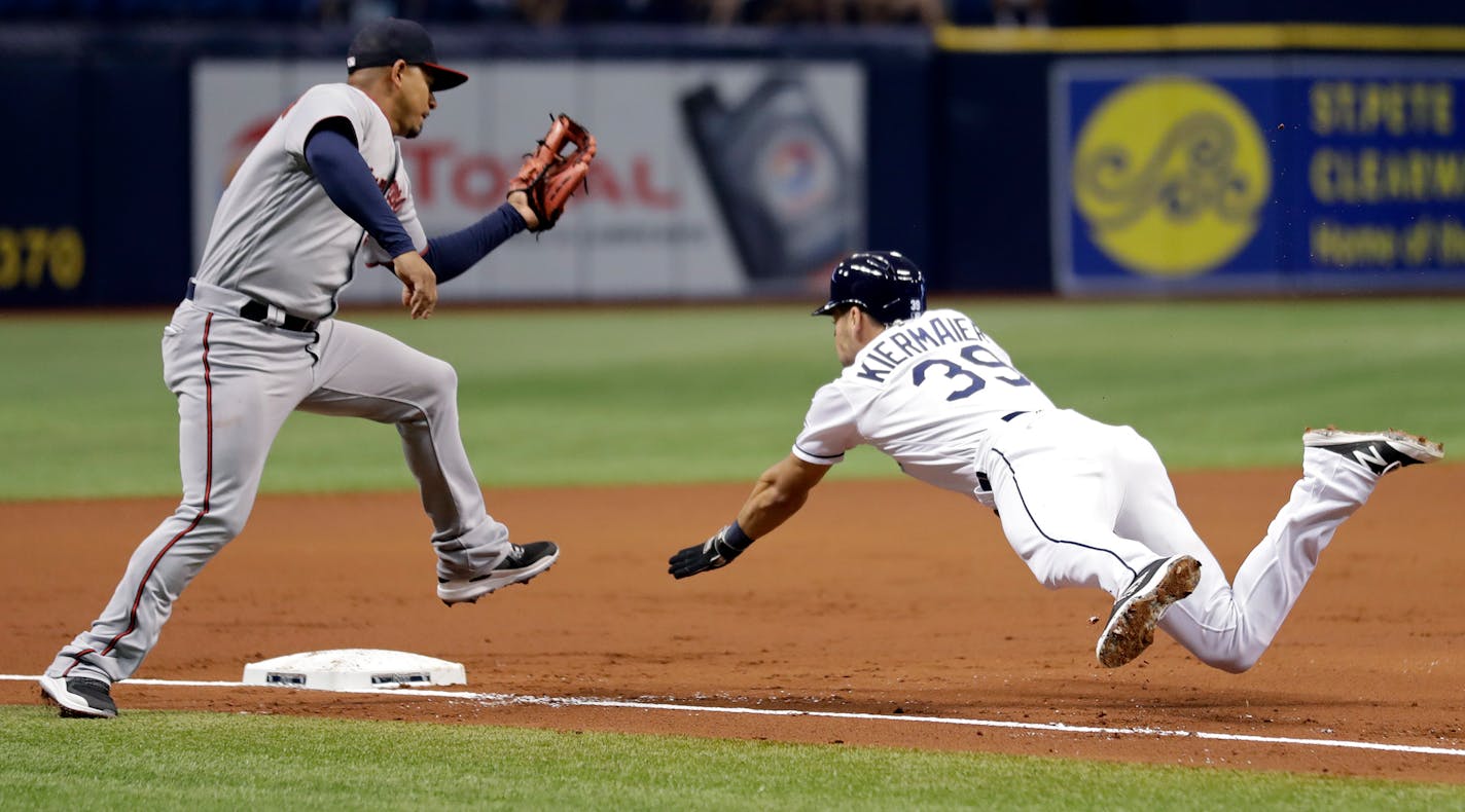 The Rays' Kevin Kiermaier dove back to third base ahead of the tag by the Twins' Eduardo Escobar during the first inning of Tampa Bay's 11-4 victory Monday.