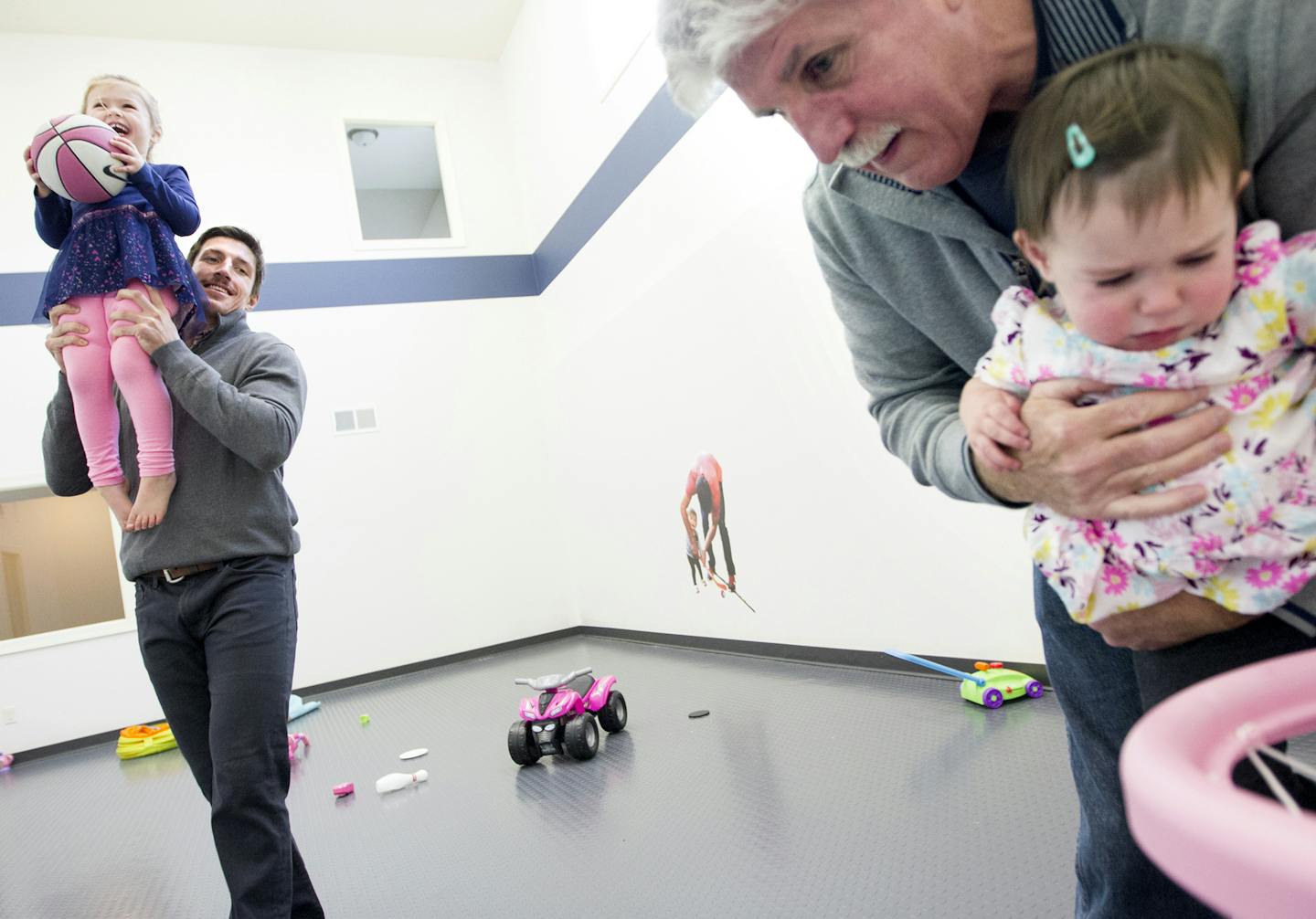 Minnesota Wild's Ryan Carter, left, holds his daughter Maggie, 3, up for a basket while his dad, Mike Carter, holds Ryan's younger daughter Natalie, 15 months, at Ryan's home in Gem Lake November 22, 2015. (Courtney Perry/Special to the Star Tribune)