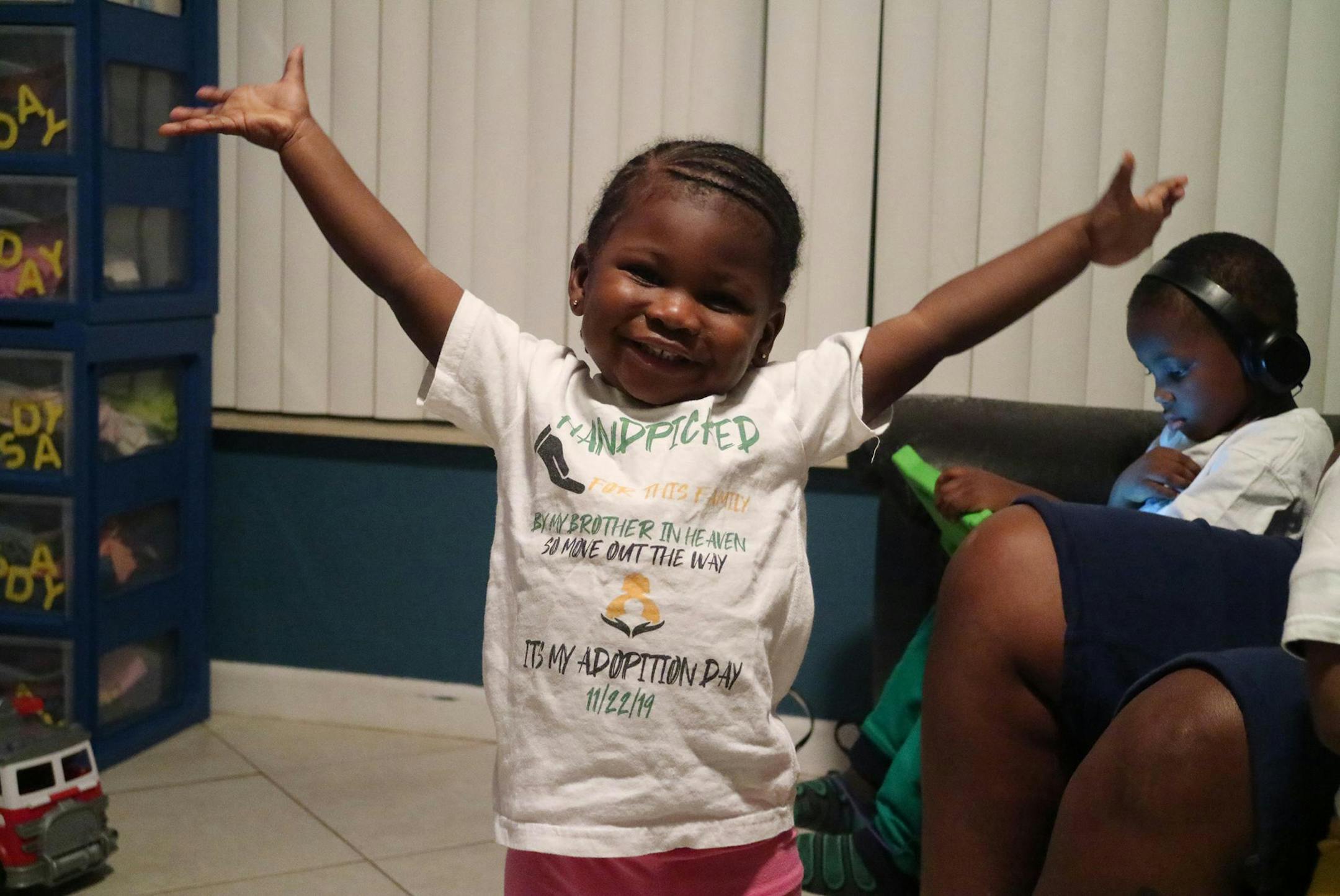 Two-year-old Zariah Senior smiles in her Boynton Beach home on Dec. 9, 2019. She is wearing the same shirt she wore on the day she and her siblings were adopted out of foster care by Monica Peoples and Michelle Senior. (Kristina Webb/Palm Beach Post/TNS)