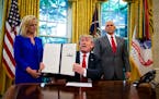 President Donald Trump, with Homeland Security Secretary Kristjen Nielsen and Vice President Mike Pence, signs an executive order Wednesday on immigra