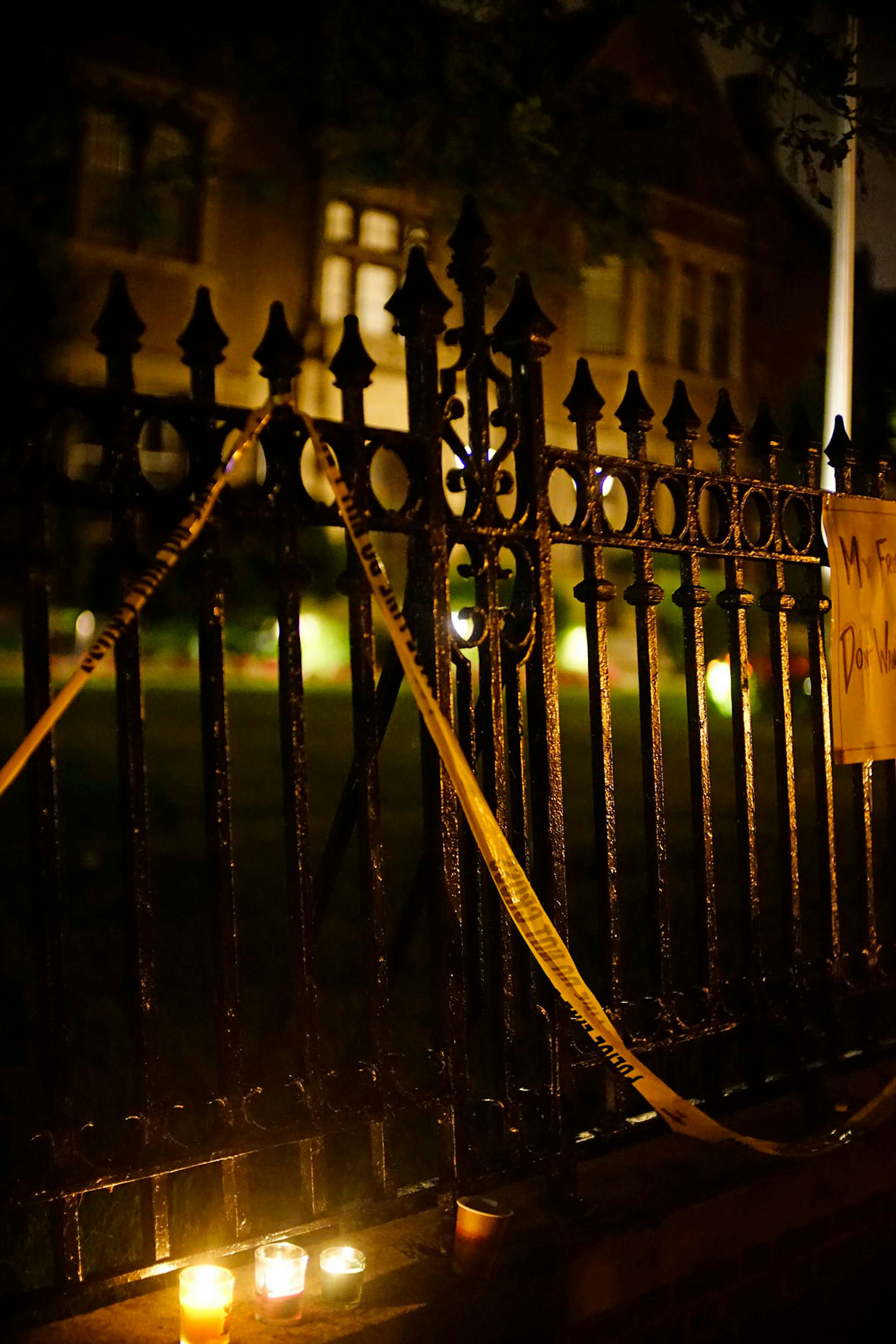Candles were lit e with police tape also used to adorn the fence.