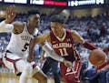 Oklahoma's Trae Young (11) dribbles the ball around Texas Tech's Justin Gray (5) during an NCAA college basketball game Tuesday, Feb. 13, 2018, in Lub