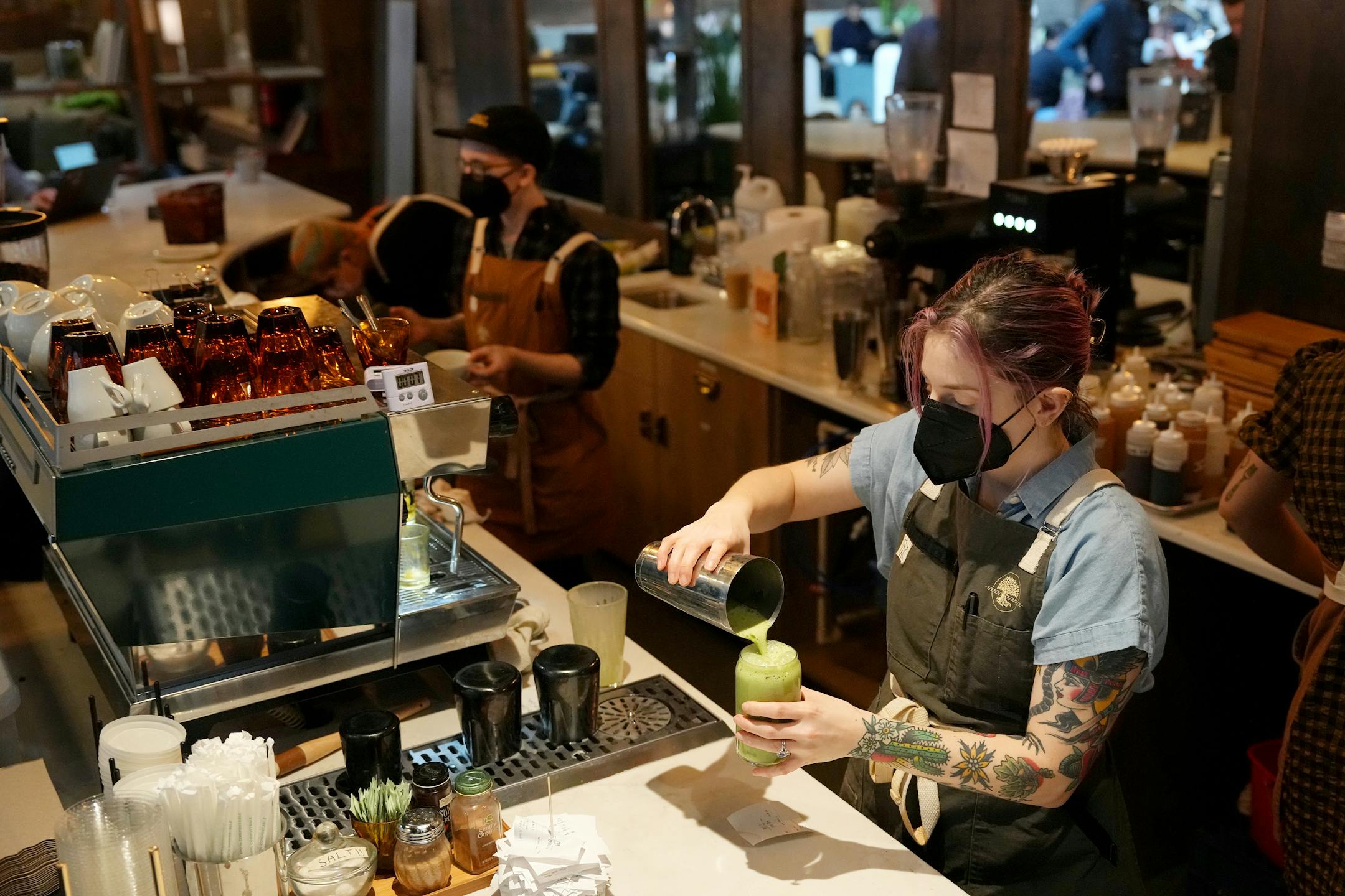 Kristina Oak, the retail manager at Backstory Coffee, makes drinks in their space in the lobby of the Duffey Lofts.