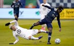 Minnesota United midfielder Emanuel Reynoso and Sporting Kansas City forward Gerso chase the ball during the first half Thursday
