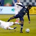 Minnesota United midfielder Emanuel Reynoso and Sporting Kansas City forward Gerso chase the ball during the first half Thursday