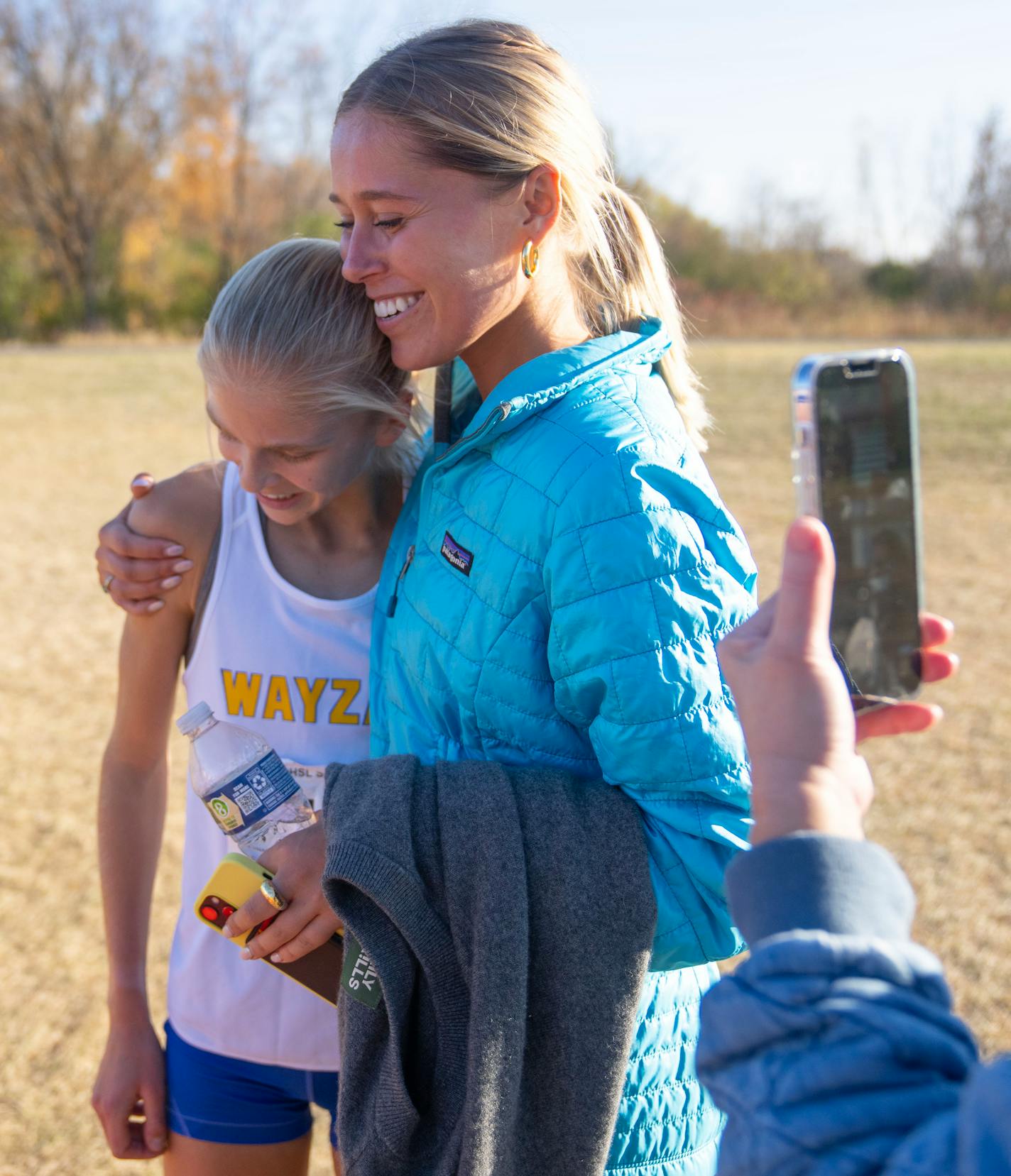 Wayzata's Abbey Nechanicky is hugged by her sister, Riley, after finishing first in the MSHSL Section 6AAA Girl's Cross Country Championships Wednesday, Oct. 26, 2022 at Gale Woods Farm in Minnetrista, Minn. Nechanicky set a personal record and course record of 16:43.70. ]