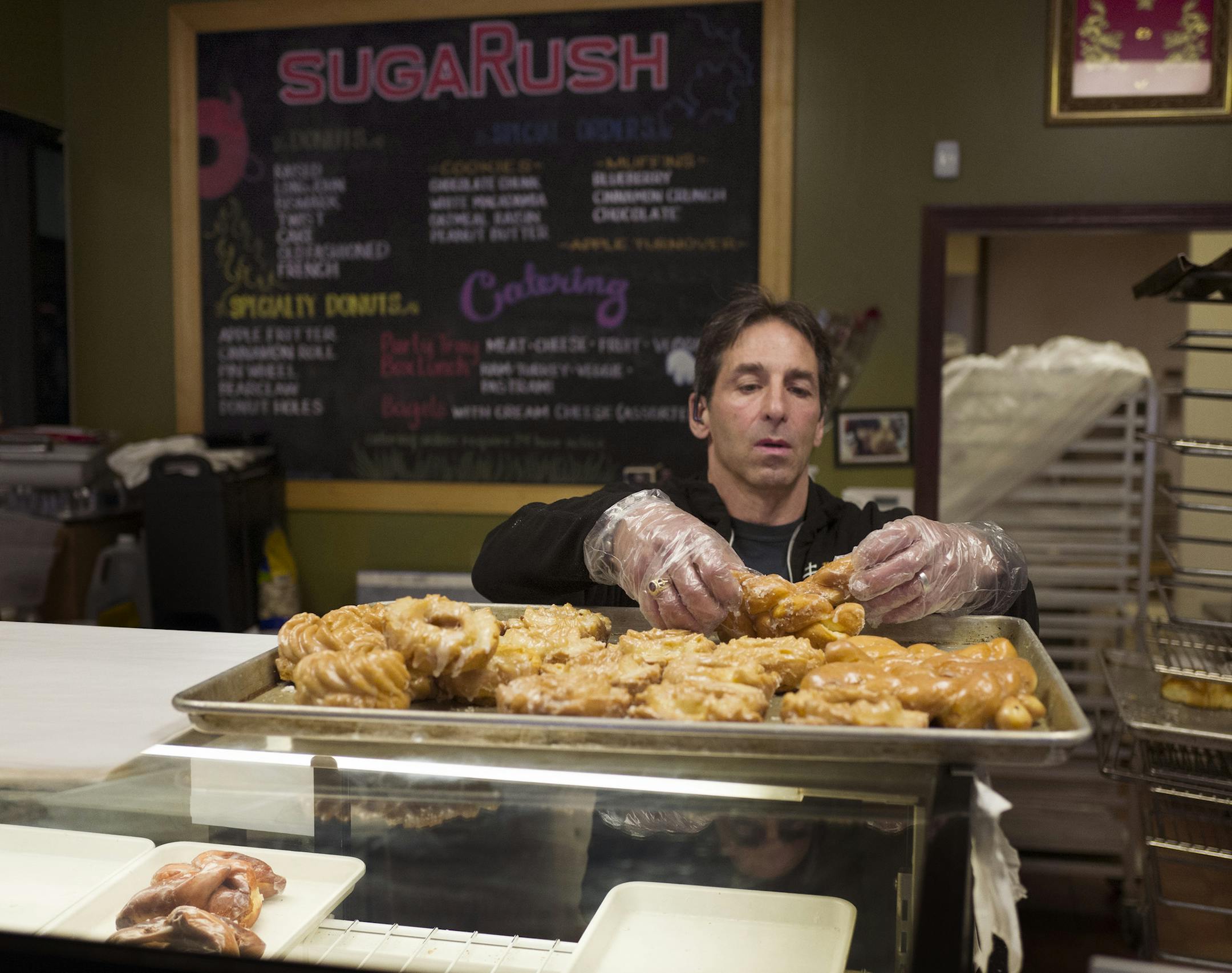 Chris Engelmann gathered fresh unsold donuts Tuesday from the SugaRush bakery May 10, 2016 in St. Paul, MN.] Chris Engelmann loaded donuts from the SugaRush bakery that he gives to homeless shelters, hospices, street people and even late-night concertgoers. Jerry Holt /Jerry.Holt@Startribune.com