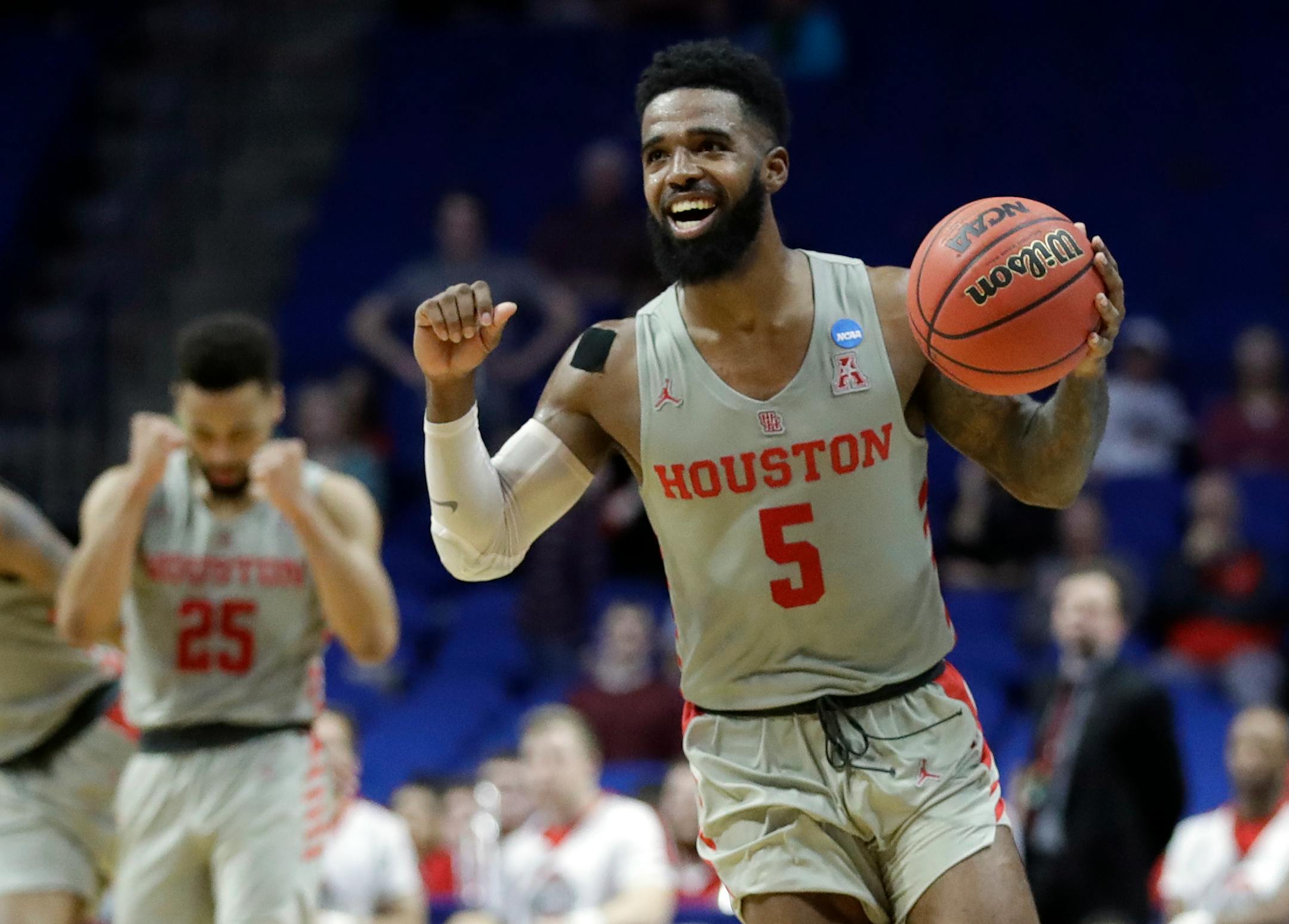 Houston's Corey Davis Jr. (5) and Galen Robinson Jr. (25) begin to celebrate in the final second during the second half of a second round men's college basketball game against Ohio State in the NCAA Tournament Sunday, March 24, 2019, in Tulsa, Okla. Houston won 74-59. (AP Photo/Jeff Roberson)