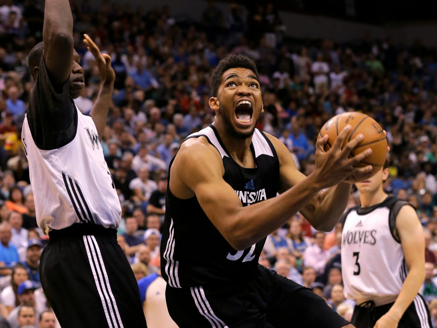 Minnesota Timberwolves center Karl-Anthony Towns, right, goes to the basket against Timberwolves center Gorgui Dieng, left, during an NBA basketball scrimmage in Minneapolis, Wednesday, July 8, 2015. (AP Photo/Ann Heisenfelt)