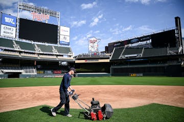 Grounds crew member Reid Olson cut the grass near second base last month at Target Field.