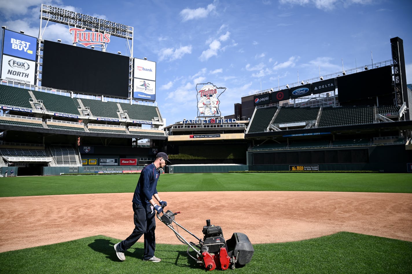 Grounds crew member Reid Olson cut the grass near second base last month at Target Field.