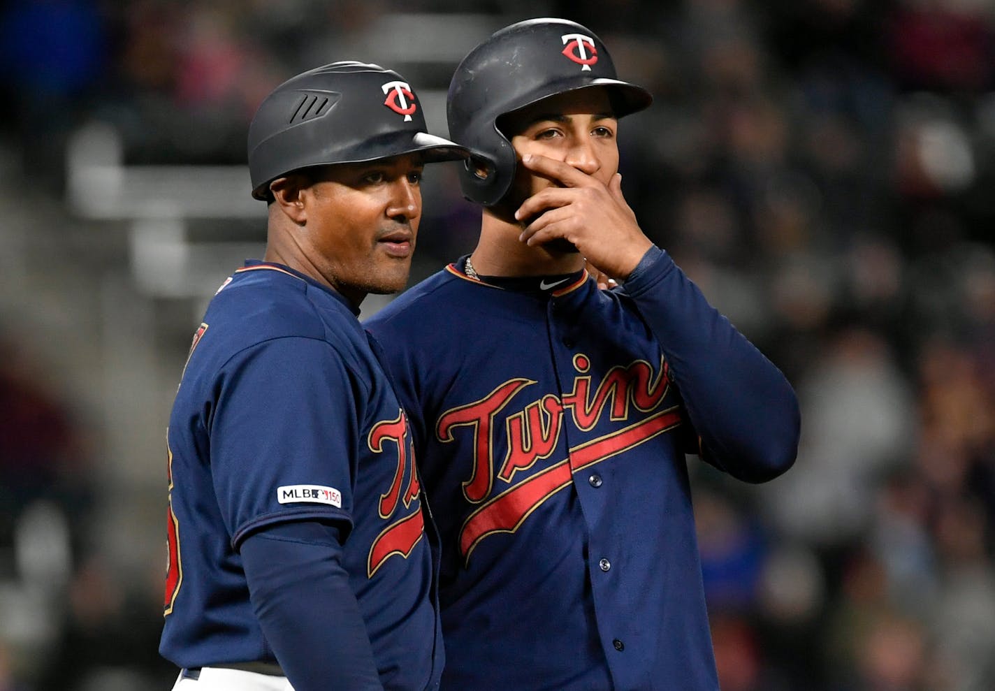 Minnesota Twins Eddie Rosario talks with third base coach Tony Diaz during the fourth inning in the second baseball game of a doubleheader, Saturday, May 11, 2019, in Minneapolis. Twins won 8-3. (AP Photo/Craig Lassig)