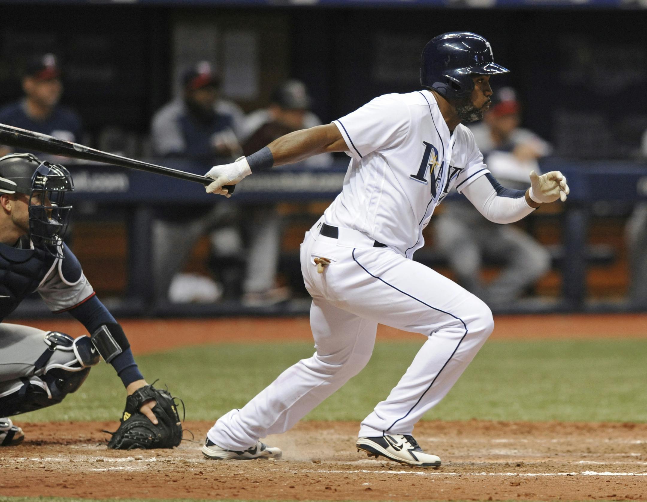Minnesota Twins catcher Mitch Garver, left, watches as Tampa Bay Rays' Denard Span, right, hits a two-run double off Twins reliever Gabriel Moya during the inning of a baseball game Saturday, April 21, 2018, in St. Petersburg, Fla. (AP Photo/Steve Nesius)