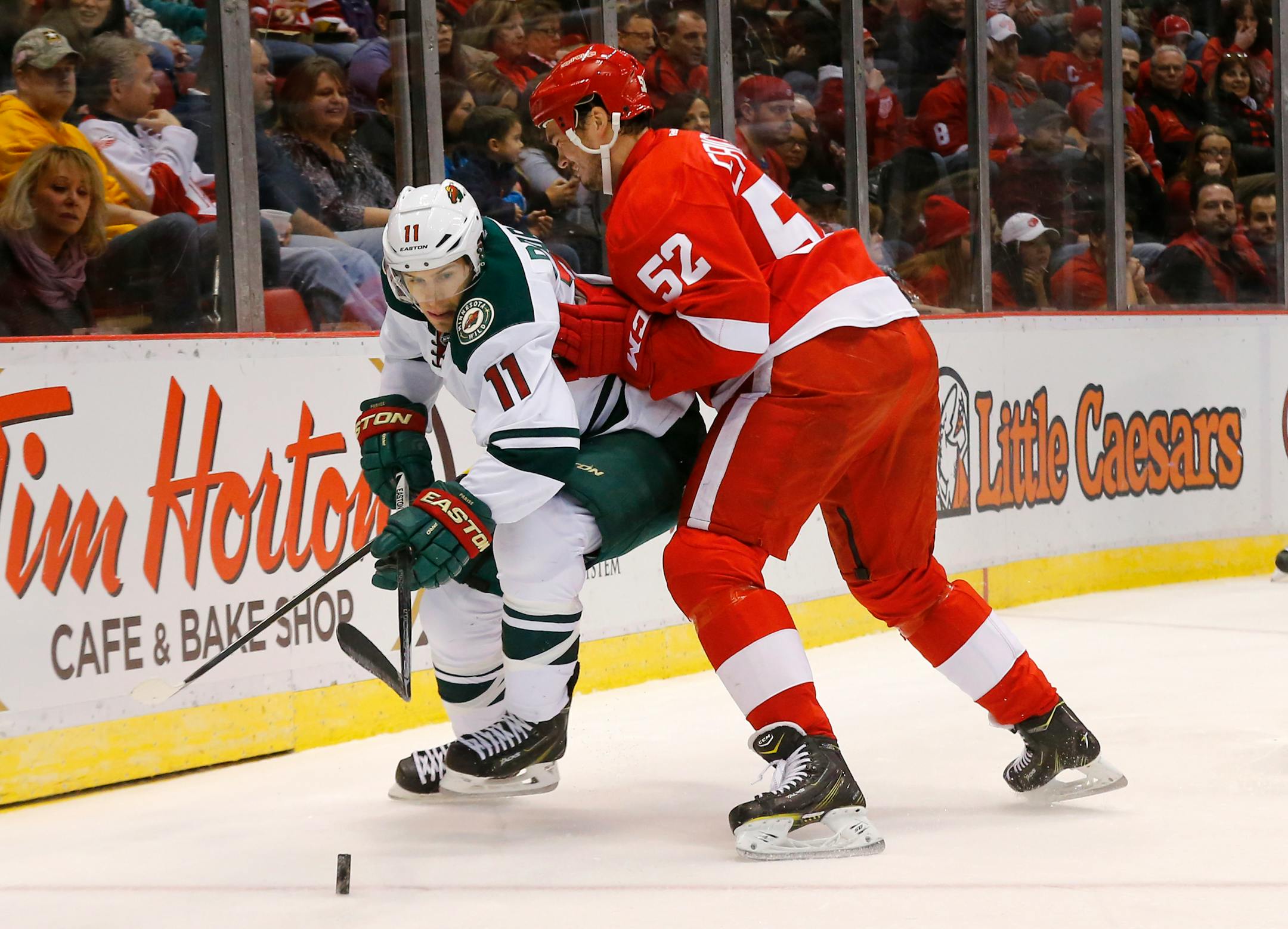 Detroit Red Wings defenseman Jonathan Ericsson (52) defends Minnesota Wild left wing Zach Parise (11) in the first period of an NHL hockey game in Detroit Tuesday, Jan. 20, 2015. (AP Photo/Paul Sancya)