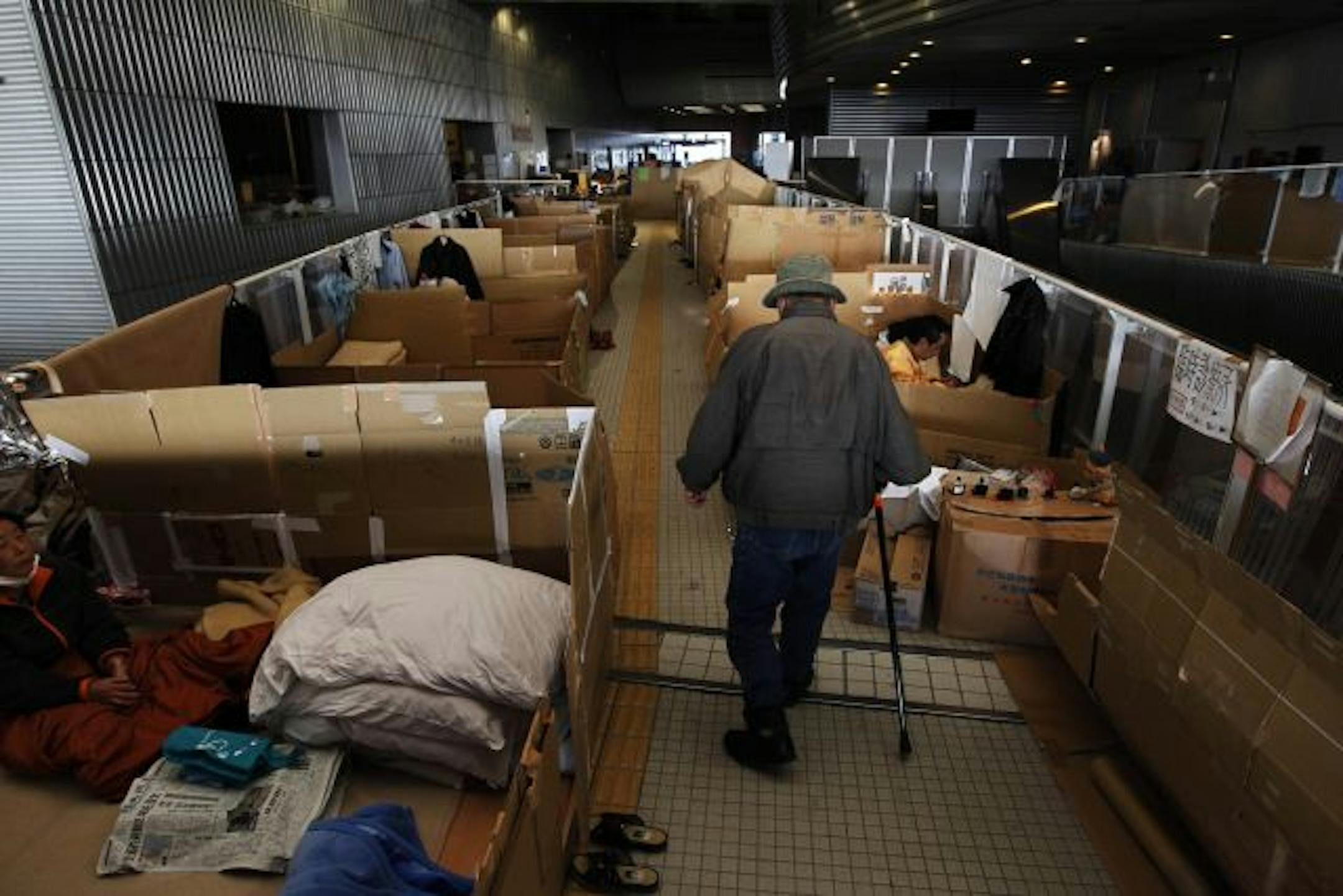 An elderly man negotiated the path made between spaces for refugees at the emergency center set up at the Big Palette Fukushima sports arena in Koriyama in northeastern Japan.