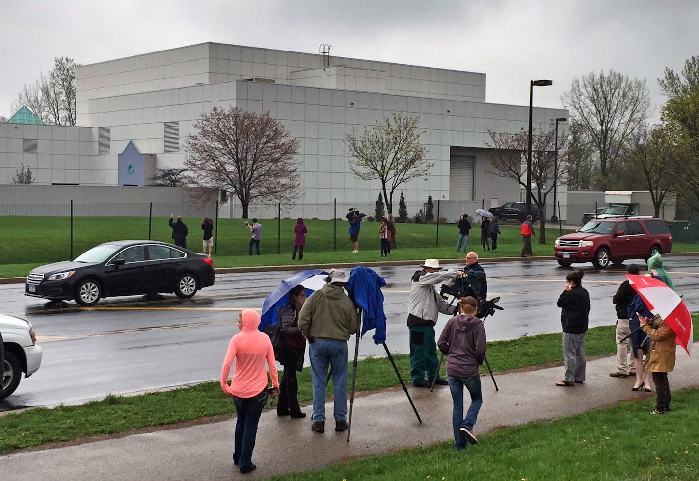 FILE - In this April 21, 2016 file photo, people stand outside entertainer Prince's Paisley Park compound in Chanhassen, Minn. Court filings in Prince's estate show that a special administrator, and likely Prince's siblings, are eager to explore the money-making potential of making a tourist attraction out of his Paisley Park home and studio complex. (Jim Gehrz/Star Tribune via AP, File) MANDATORY CREDIT; ST. PAUL PIONEER PRESS OUT; MAGS OUT; TWIN CITIES LOCAL TELEVISION OUT TV is soft out