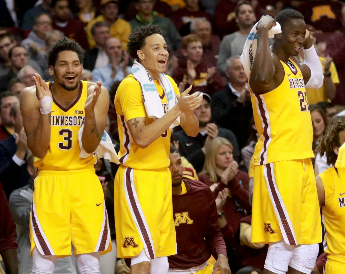 Jordan Murphy (3), Amir Coffey (5), and Bakery Konate (21) react as their team pulls ahead near the end of the first half against Louisiana-Lafayette.