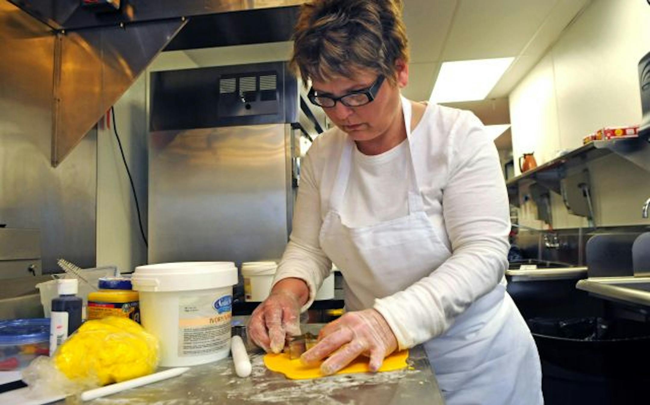 Penny Steele has brought her bakery back to Minneapolis. Above left, cakes made to look like fast food.