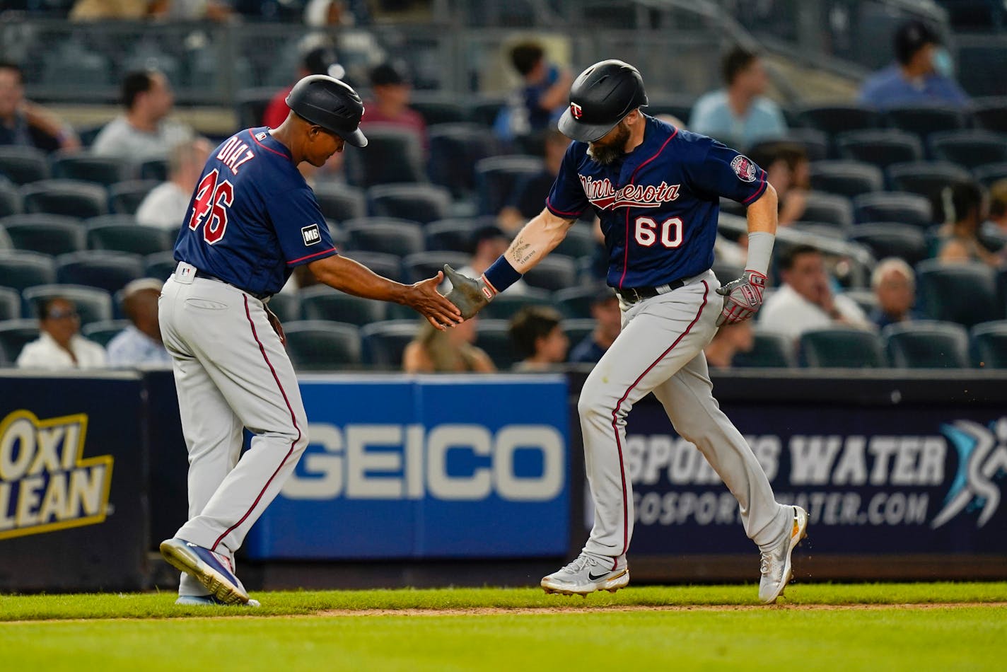 Minnesota Twins' Jake Cave (60) celebrates with third base coach Tony Diaz (46) after Cave hit a home run during the sixth inning of the team's baseball game against the New York Yankees on Thursday, Aug. 19, 2021, in New York. (AP Photo/Frank Franklin II)