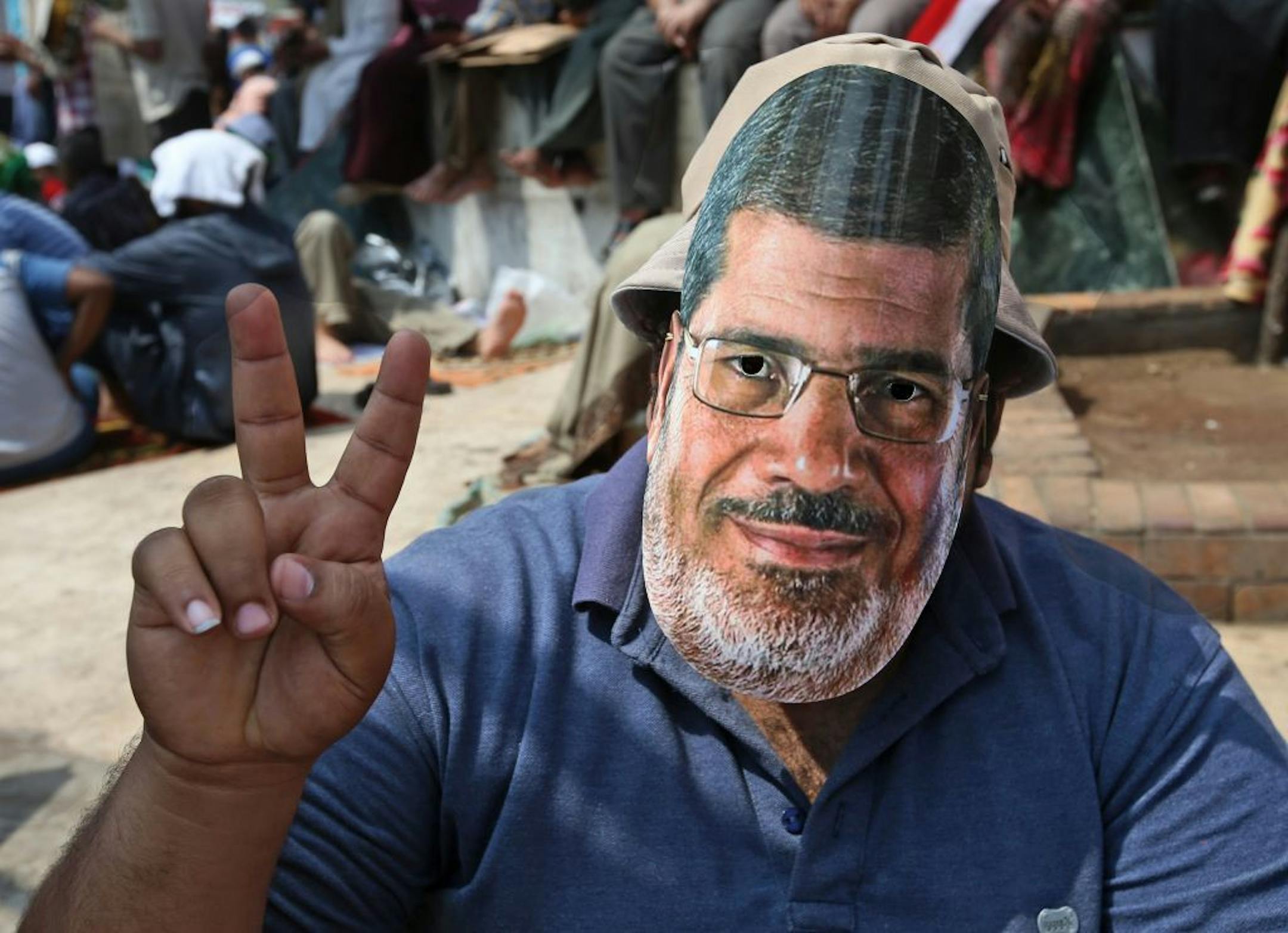 A supporter of Egypt's ousted President Mohammed Morsi wears a mask with the former leader's likeness during a demonstration before the Friday prayer, at Nasr city, Cairo, Egypt, Friday, July 12, 2013. Thousands of supporters of Egypt�s Muslim Brotherhood group rallied in a Cairo city square, waving pictures of the ousted President Mohammed Morsi and chanting anti-military slogans, deriding army chief who led Morsi�s removal as �traitor� with one ultraconservative Salafi cleric vows to stay in t
