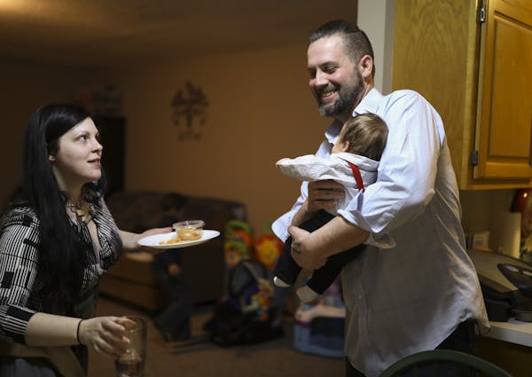 Rob Spain held his seven week-old son, Ayden, while he and the boy's mom, Tiffany Birch cleared the kitchen table after dinner. ] JEFF WHEELER &#xef; 