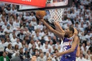 Suns forward Kevin Durant (35) lays the ball in past Timberwolves center Rudy Gobert (27) in the first quarter of a first-round NBA playoff game at Ta